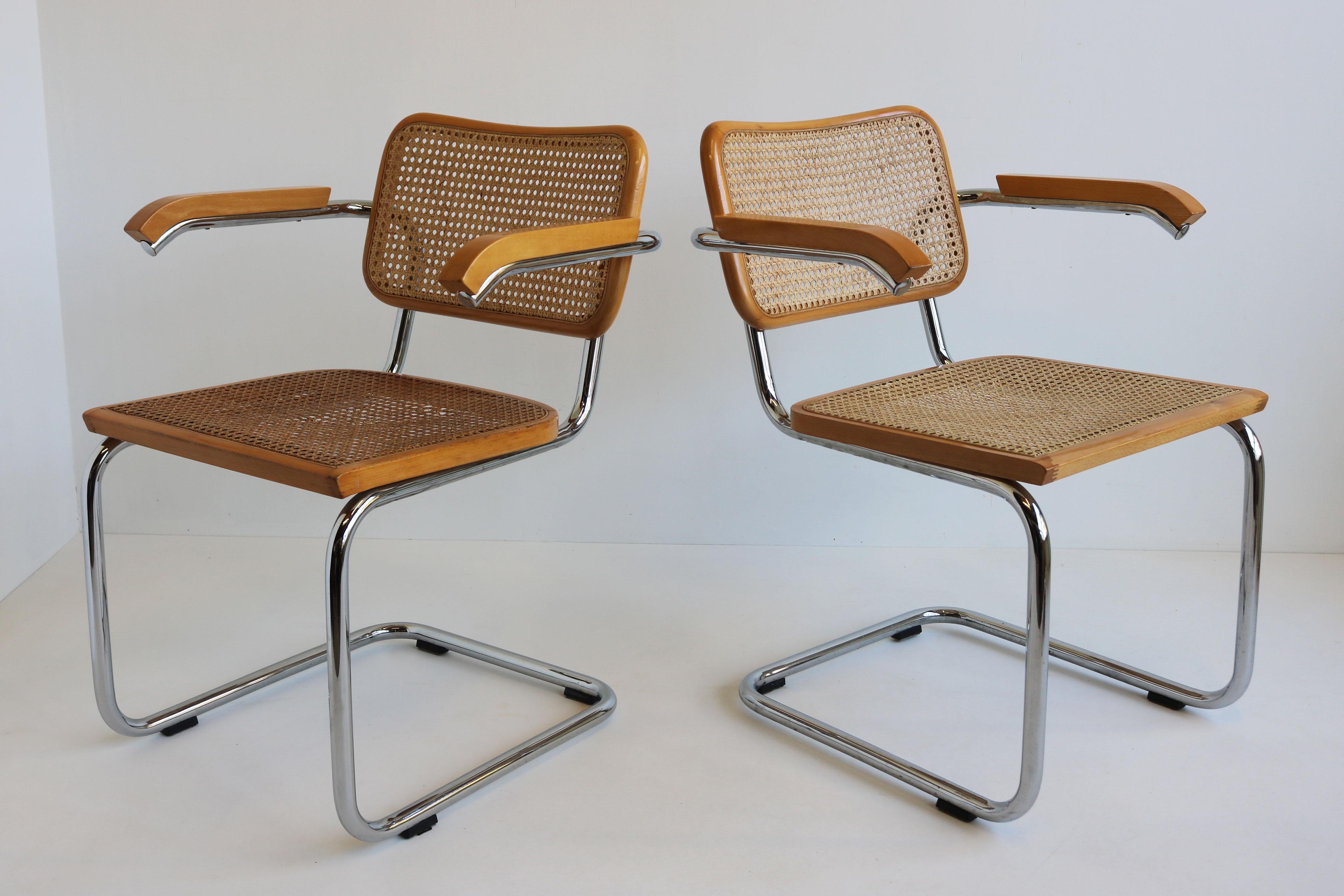 Questo set di poltrone è caratterizzato da un'elegante base tubolare a sbalzo in acciaio cromato con sedile e schienale in canne, il tutto racchiuso in una struttura in faggio. Disegnata da Marcel Breuer nel 1952, questa coppia è stata prodotta in