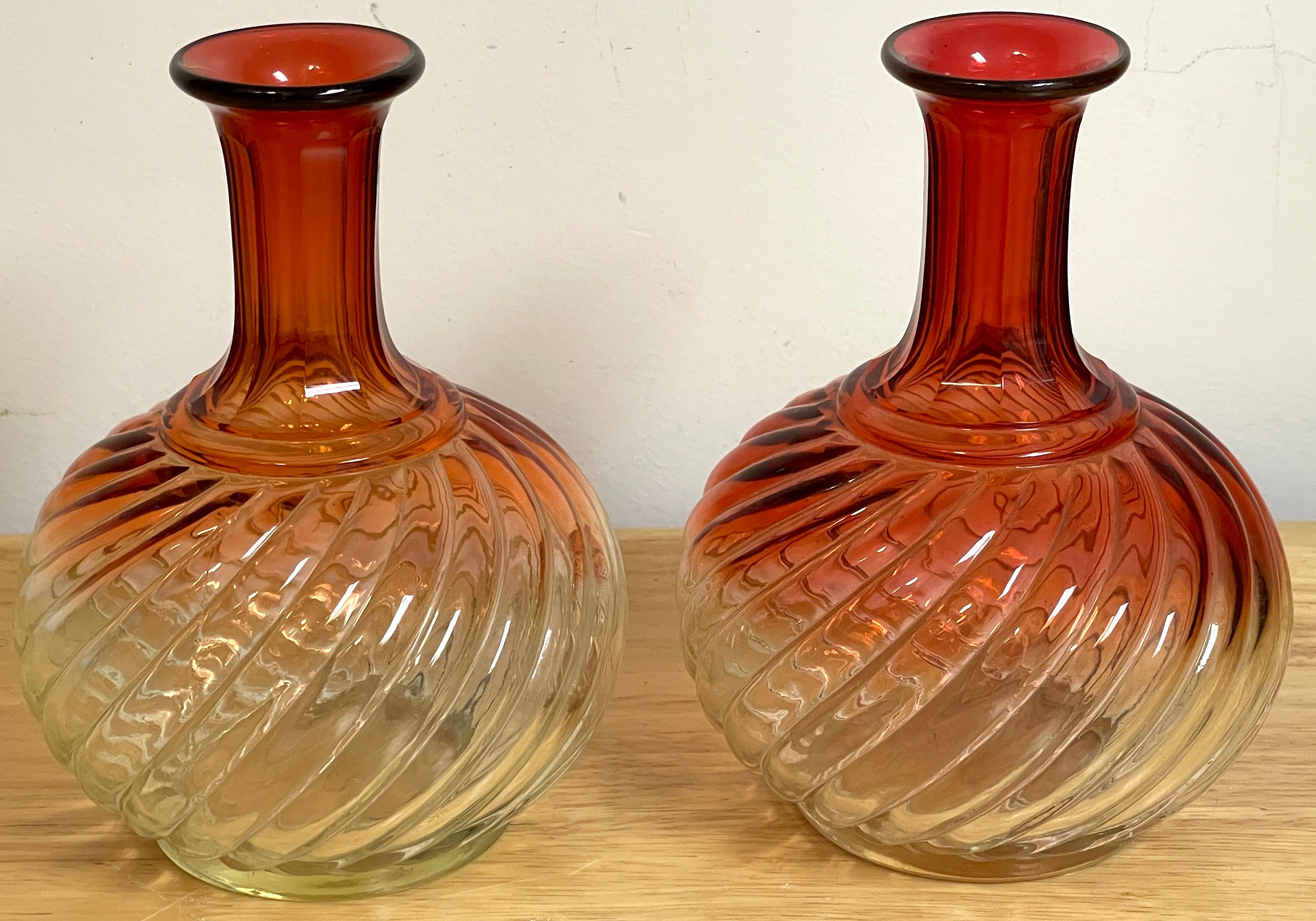 Pair of Baccarat Amberina Diminutive Claret Jugs, Each one with typical swirl design, with panel cut necks, polished bottom, unmarked. 
Each one measures 7.5