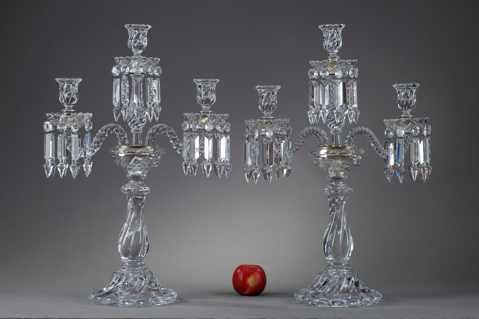 Pair of Baccarat candelabra in molded crystal with three lights decorated with crystal pendants. They are composed of two twisted arms of lights and an upper amount. The shafts are godroned. The bobeches are decorated with twists. The two