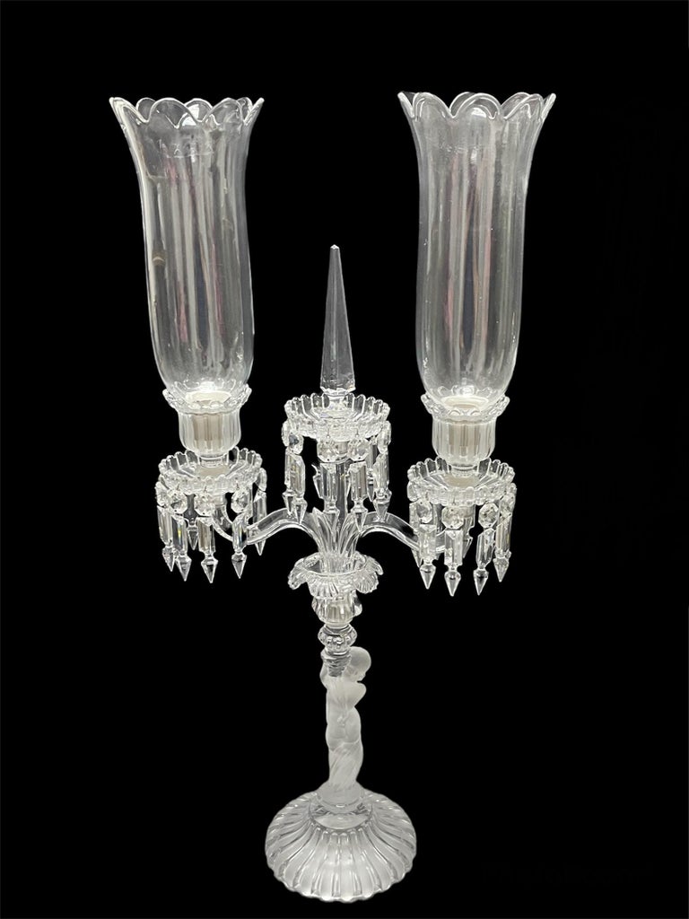 This is a pair of Baccarat “L’Enfant” clear/frosted crystal candelabras. They depict a fluted crystal round bases with stems shaped as a stand up almost nude “enfants” holding torchlights. From there, two arms come out with a straight center stem.