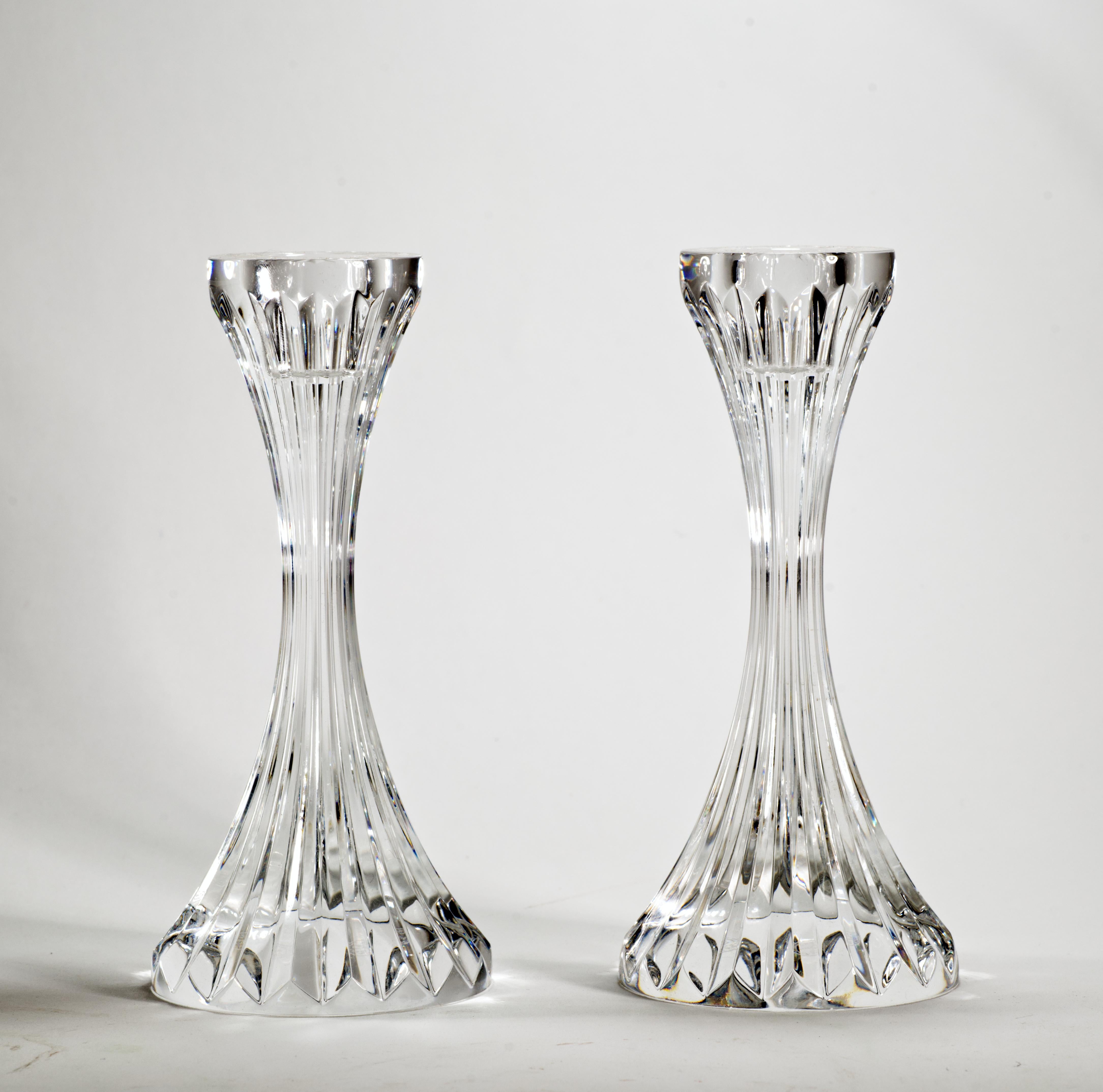  Pair of Baccarat Massena single light candlesticks have deep bevel cuts that are etched directly into the clear crystal, irradiating from the foot of the candlestick to the base of the narrow bowl. Wide, heavy base adds stability and balances the