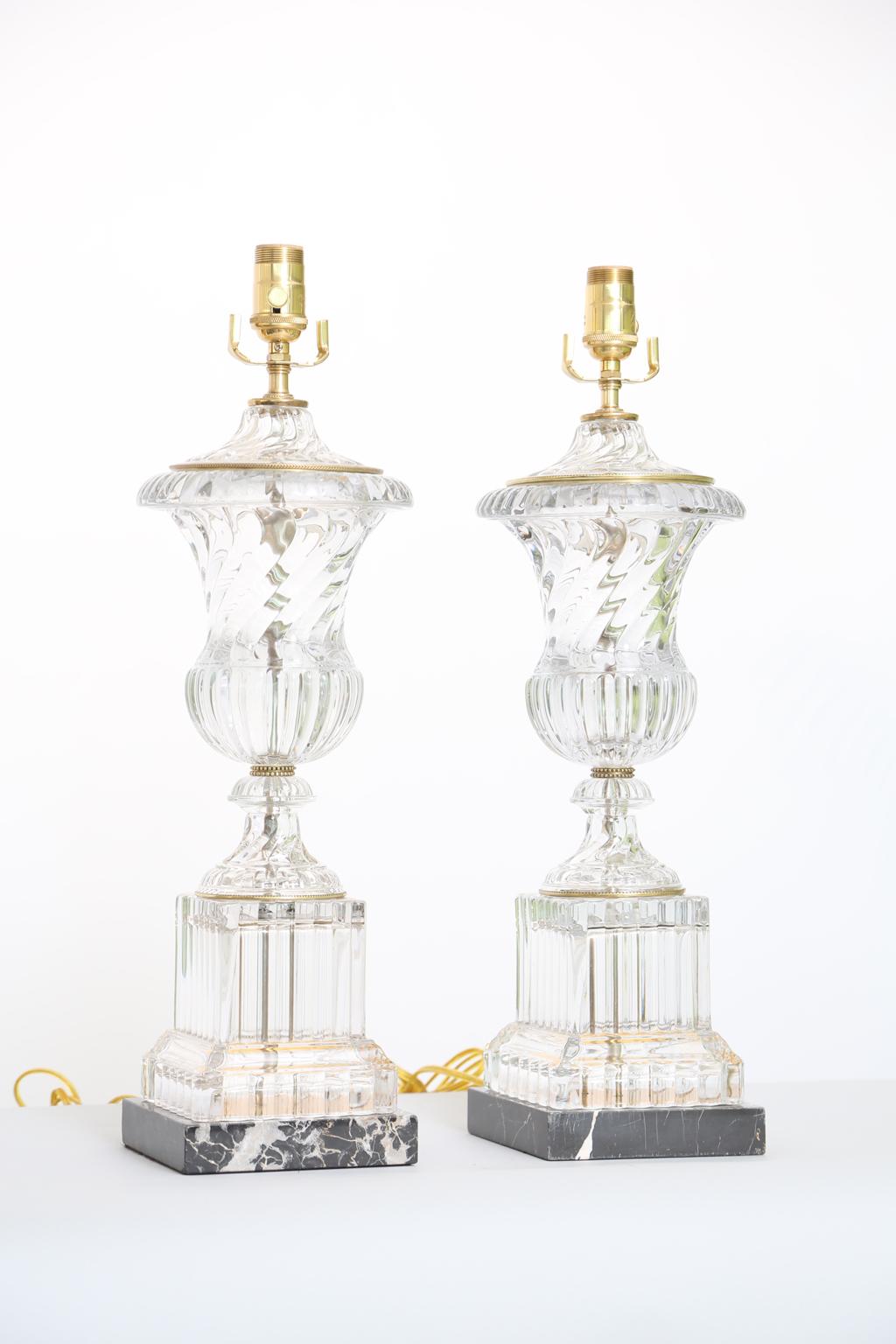 Fine pair of urn shaped lamps by Paul Hanson, from the original Baccarat molds, of spiral fluted glass, raised on round foot, on square glass plinth, finished on black veined marble base.

Stock ID: D2650.