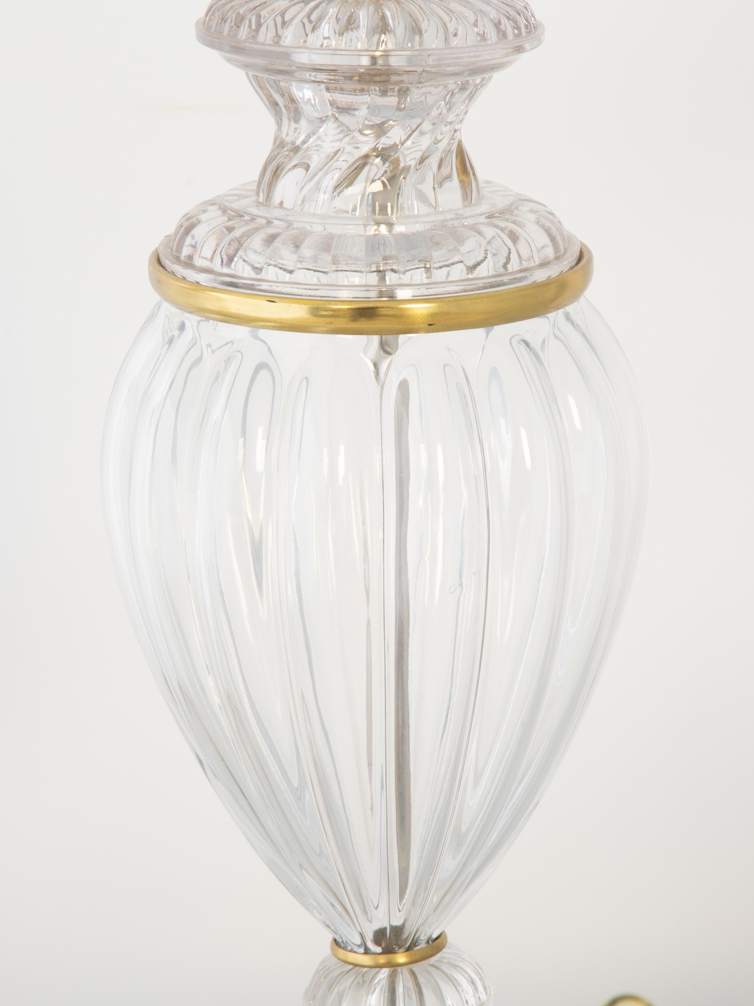 Pair of Paul Hansen Baccarat lamps, of glass, with polished brass accents. Each a reeded, baluster-form urn, on graduated round foot, set upon a brass plinth base.

A second, identical pair of lamps is available.

Stock ID:  D8182