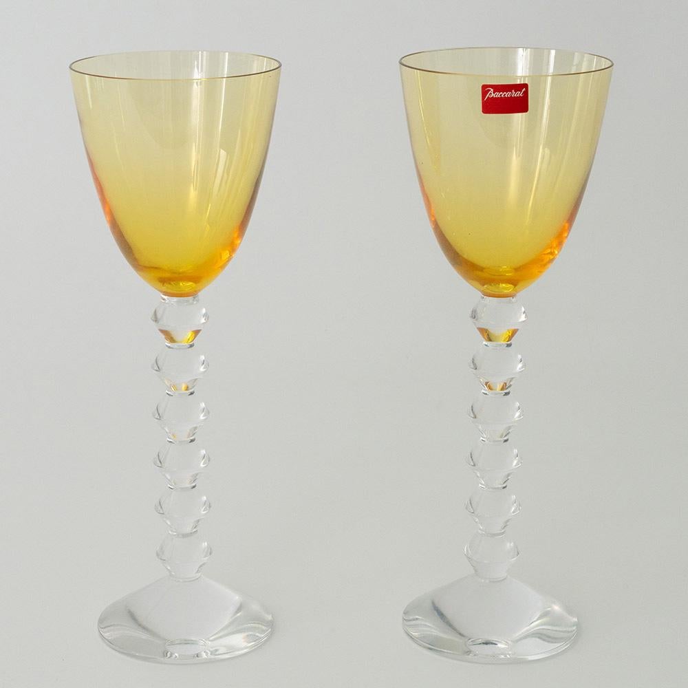 Heading :  Pair of Baccarat Vega wine glasses with amber bowls
Period : Modern
Origin : Baccarat, France
Colour : Amber bowls with clear stems and feet
Bowl : Round funnel
Stem : Formed of angular knops not dissimilar to a bobbin stem on a Georgian
