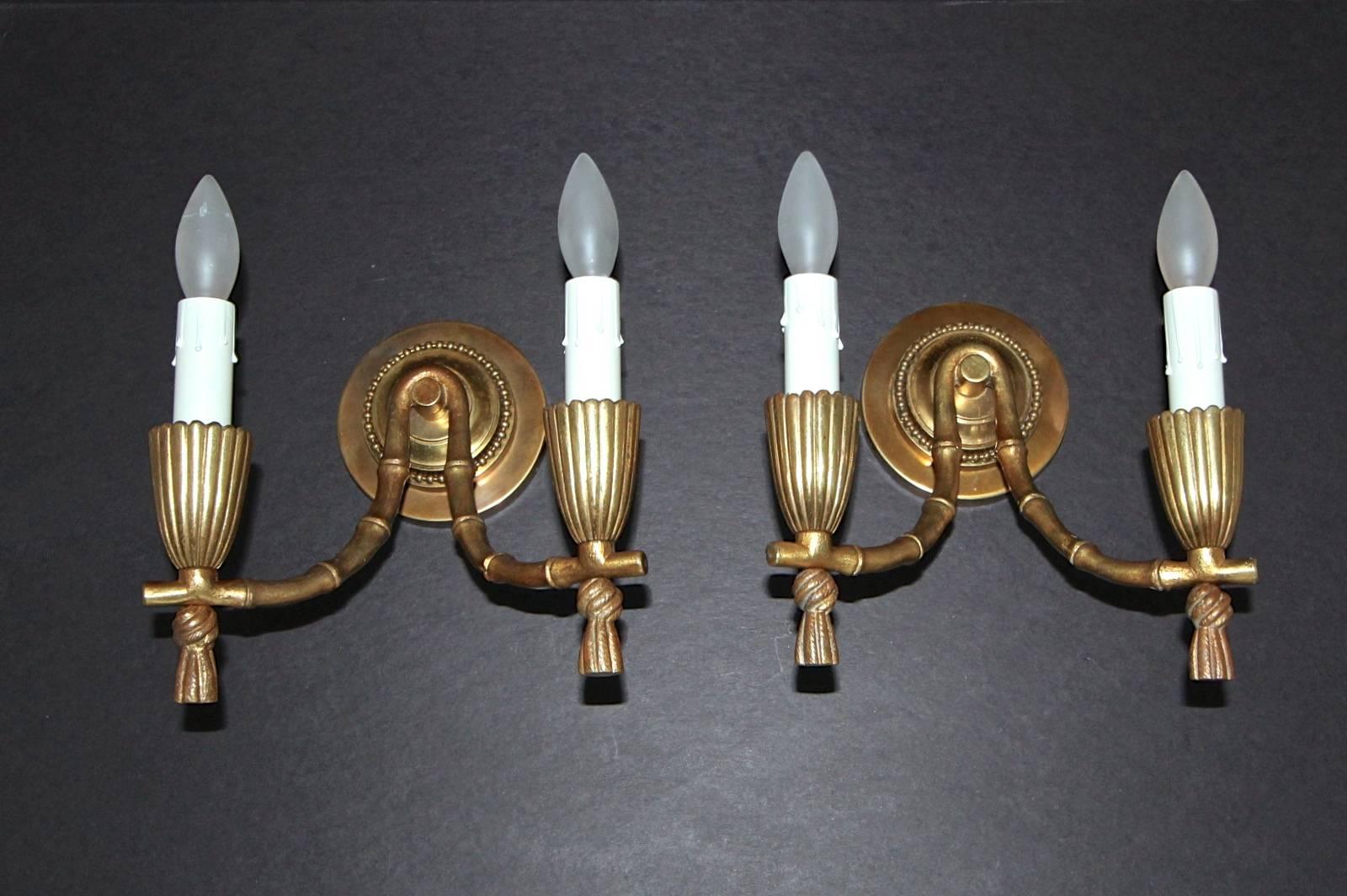 Pair of bronze faux bamboo two-light wall sconces attributed to Maison Baguès. Curved faux bamboo draped over a center rod with ribbed bobeche a tassel finials. Each sconces uses two candelabra base bulbs, newly wired.

A custom 4
