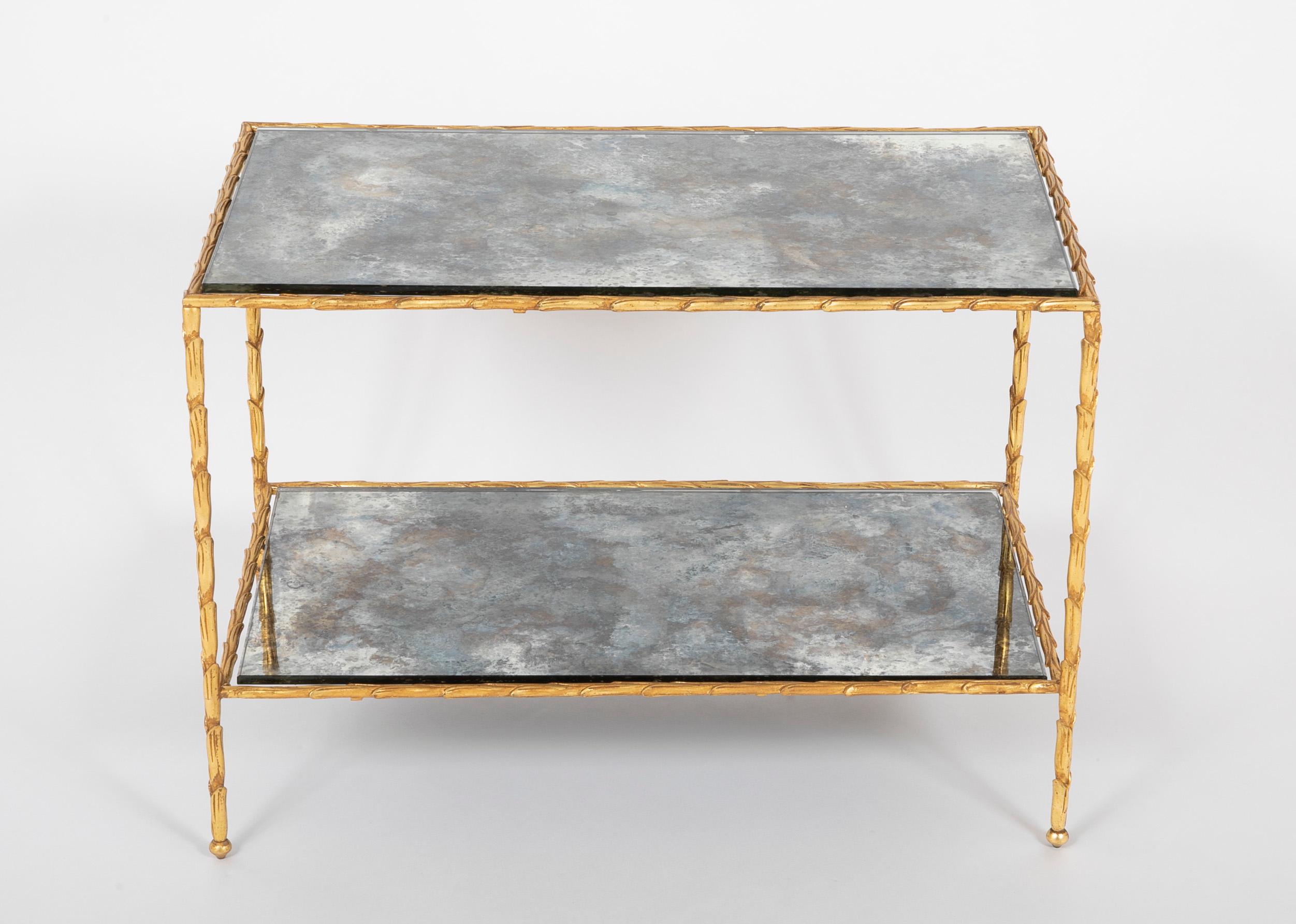 Pair of Bagues gilt bronze end tables, with vegetal motif gilt bronze frames and fitted with two tiered smoked antiqued mirrored glass.