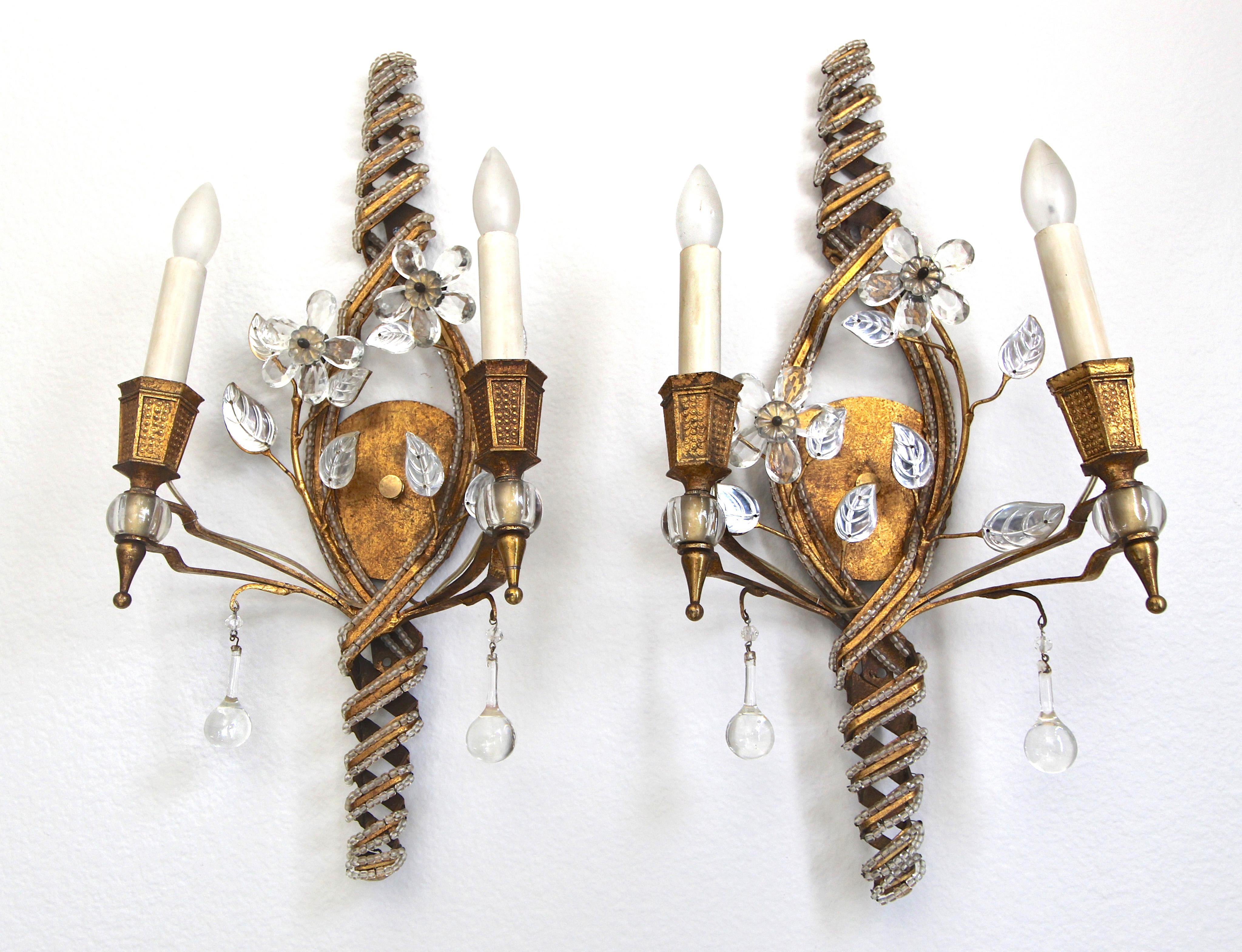 Pair of French beaded and gilt iron sconces with crystal flowers and leaves motif, attributed to Maison Baguès. Each sconce uses two candelabra base bulbs.