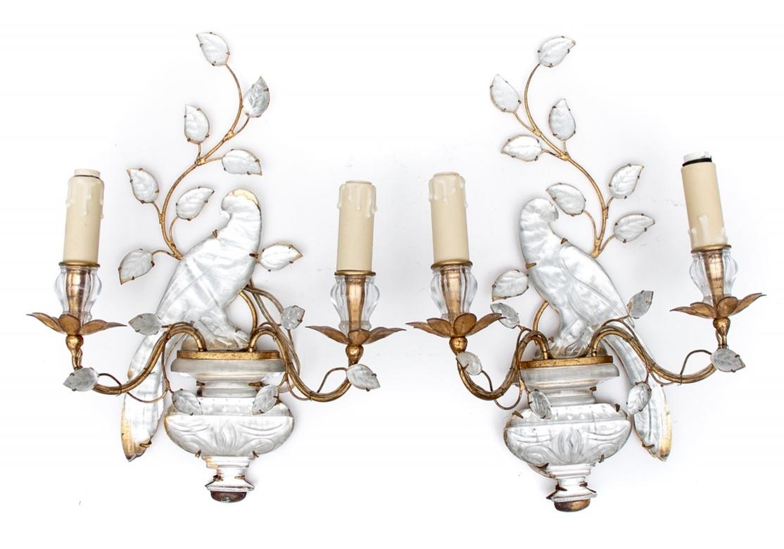 Authentic vintage Bagues Paris sconces with label on the back. Beautifully crafted twin light sconces with crystal opposing parrots mounted on etched crystal neoclassical footed urns. Gilt metal branches with crystal leaves scroll up from the urns.