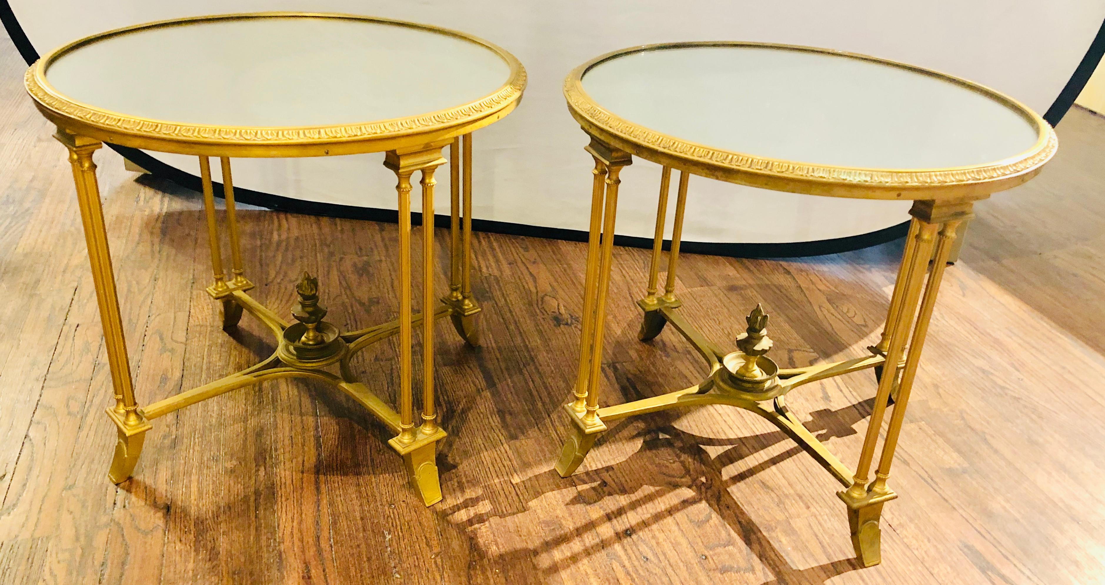 Pair of Hollywood Regency Bagues style gilt bronze neoclassical end tables or pedestals. These simply stunning end tables, pedestals or nightstands possess the finest in quality and form. The doré bronze frames having carved feet leading to double