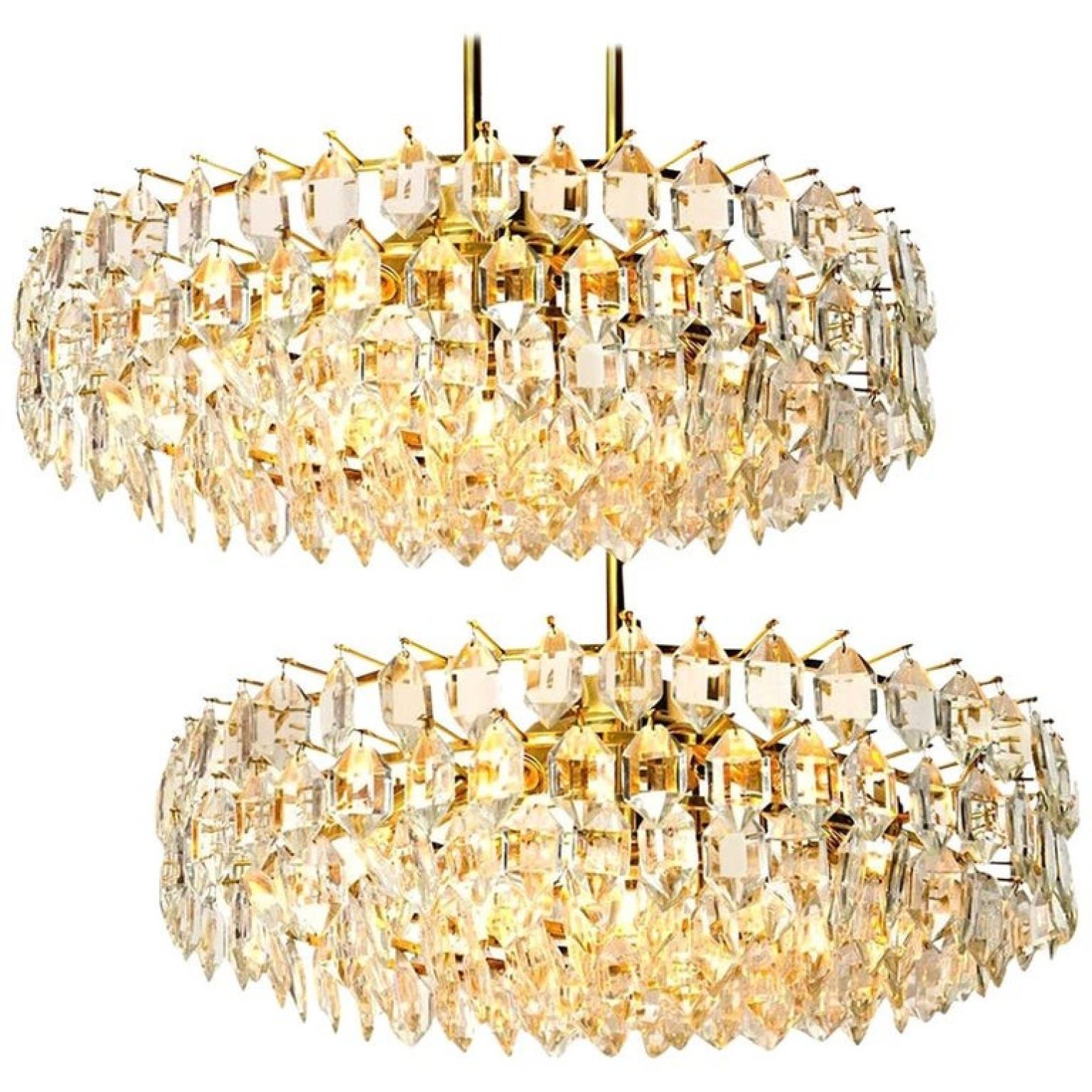 A pair of elegant chandeliers by Bakalowits & Sohne, Austria. The chandeliers are manufactured in circa 1960-1969. With huge gem-like crystals and gilded brass frame. The crystals are meticulously cut in such a way that radiate the light of the