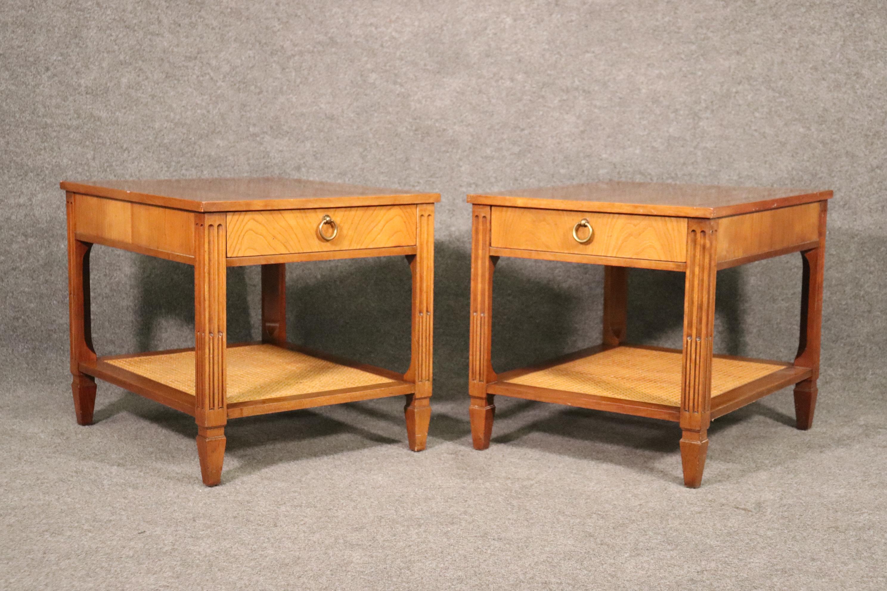 This is a beautiful pair of Baker cherry Mid-Century Modern end tables with cane bases. They are in good condition. The tables measure 27 deep x 22 wide x 22 tall.