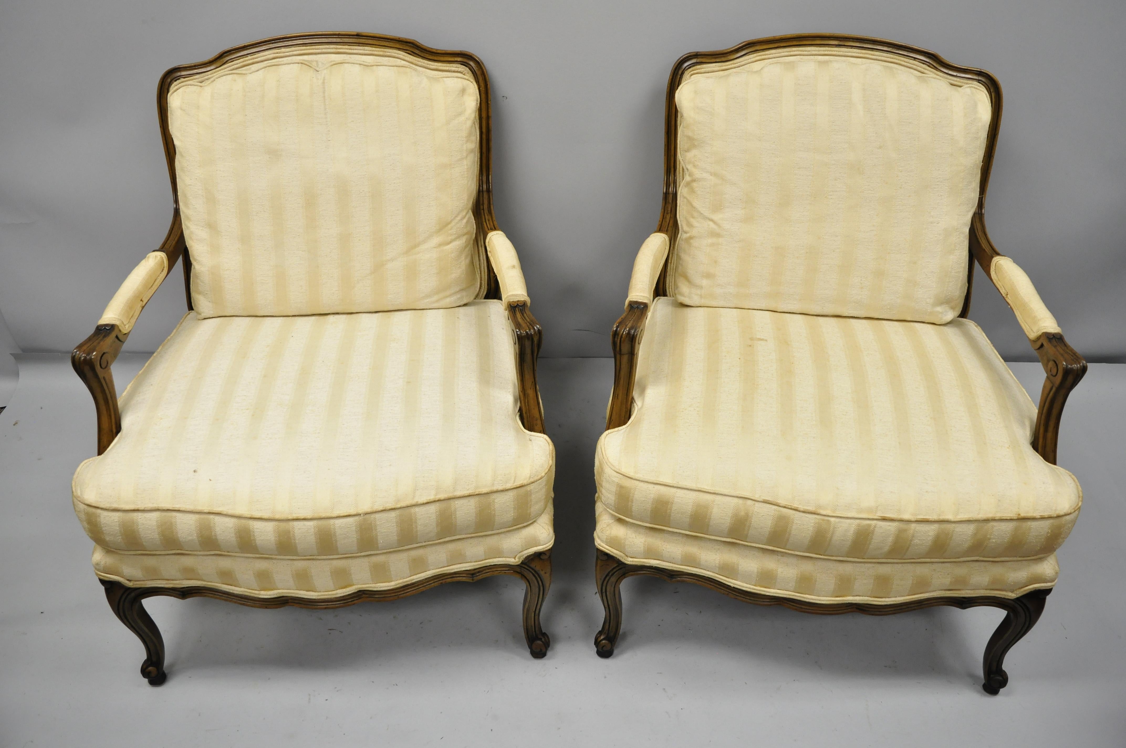 Pair of Baker French Country Provincial Louis XV style bergère armchairs. Item features nice wide seats, tight sturdy frames, solid wood construction, distressed finish, original label, cabriole legs, and quality American craftsmanship. Mid-20th