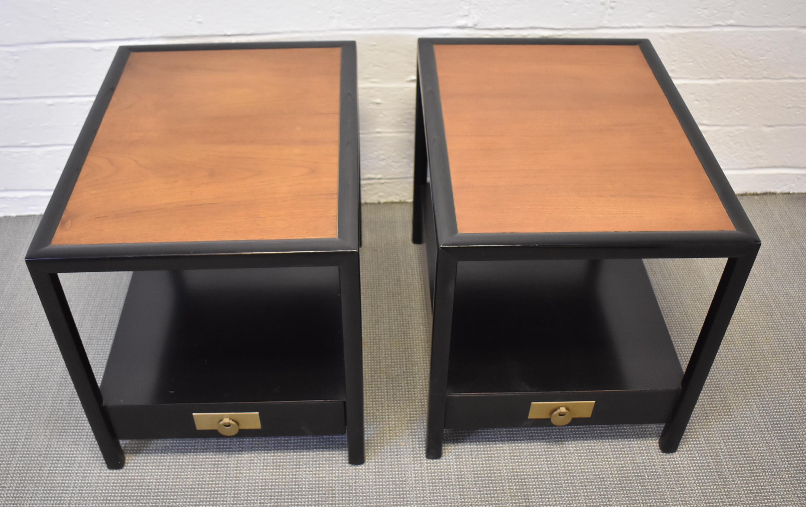 Pair of baker furniture Hollywood Regency end tables by Michael Taylor. Circa 1950's Mid-Century Modern Style. They each feature natural mahogany wood construction and drawers with original ebonized finish and brass hardware. Excellent vintage