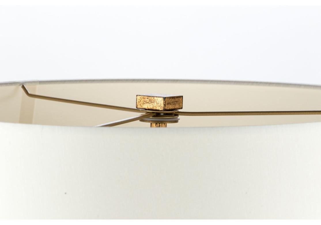 Light, airy and fine pair of Lamps from the Milling Road division of Baker Furniture. A cage form table lamp featuring a short cylindrical shade supported by three gold leaf stems conjoined with circular stretchers. The lamp takes candelabra base