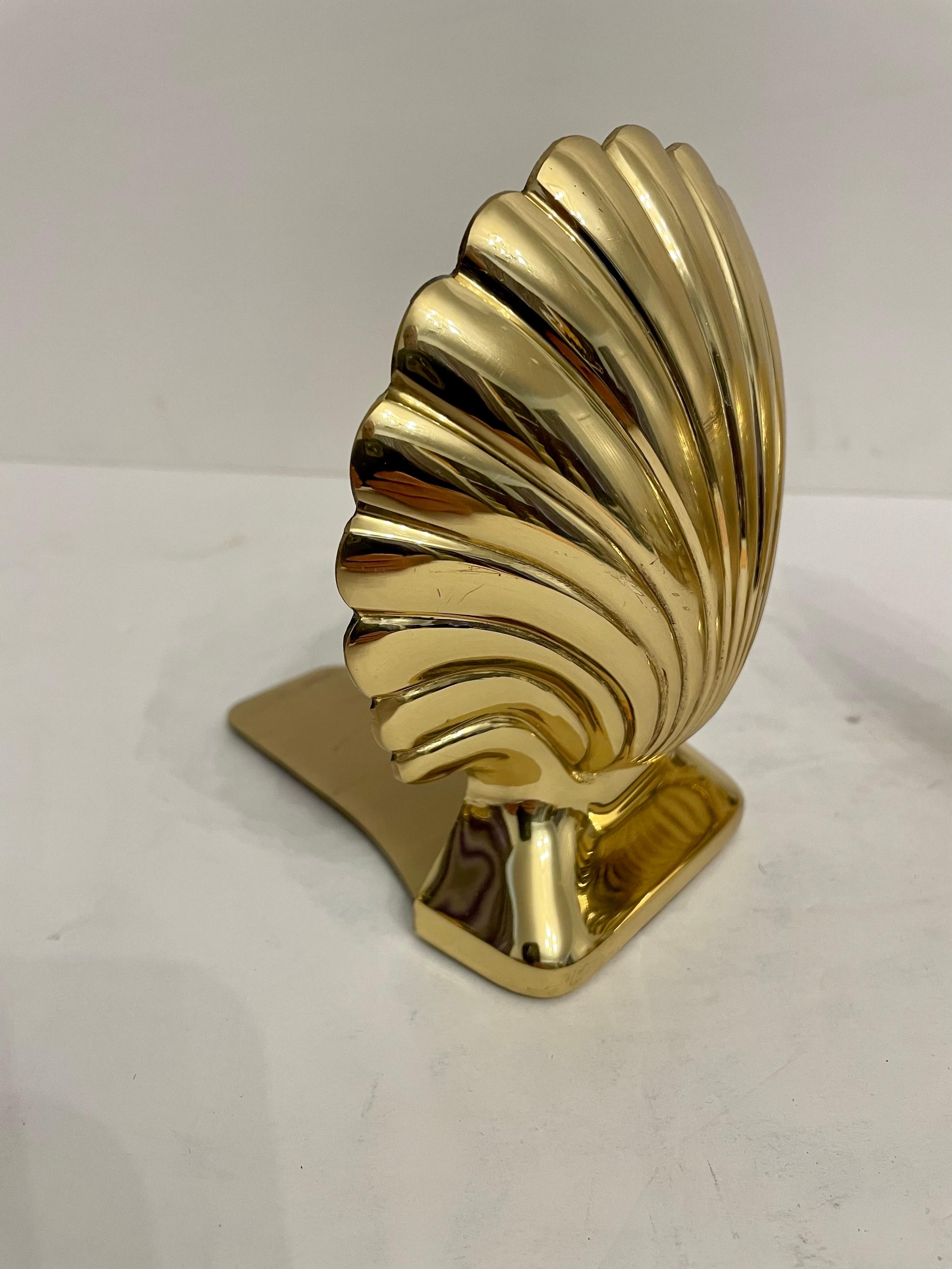 Pair brass clam shell seashell bookends made by Baldwin Brass Company from the Henry Ford & Greenfield Village Collection. 
Each Bookend stands 6” high and 5” wide including the tongue of the base that slips under books to hold them in place, each