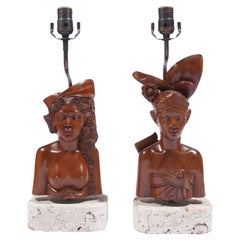 Pair of Balinese carved bust lamps mounted on cut coral bases, c. 1920-40