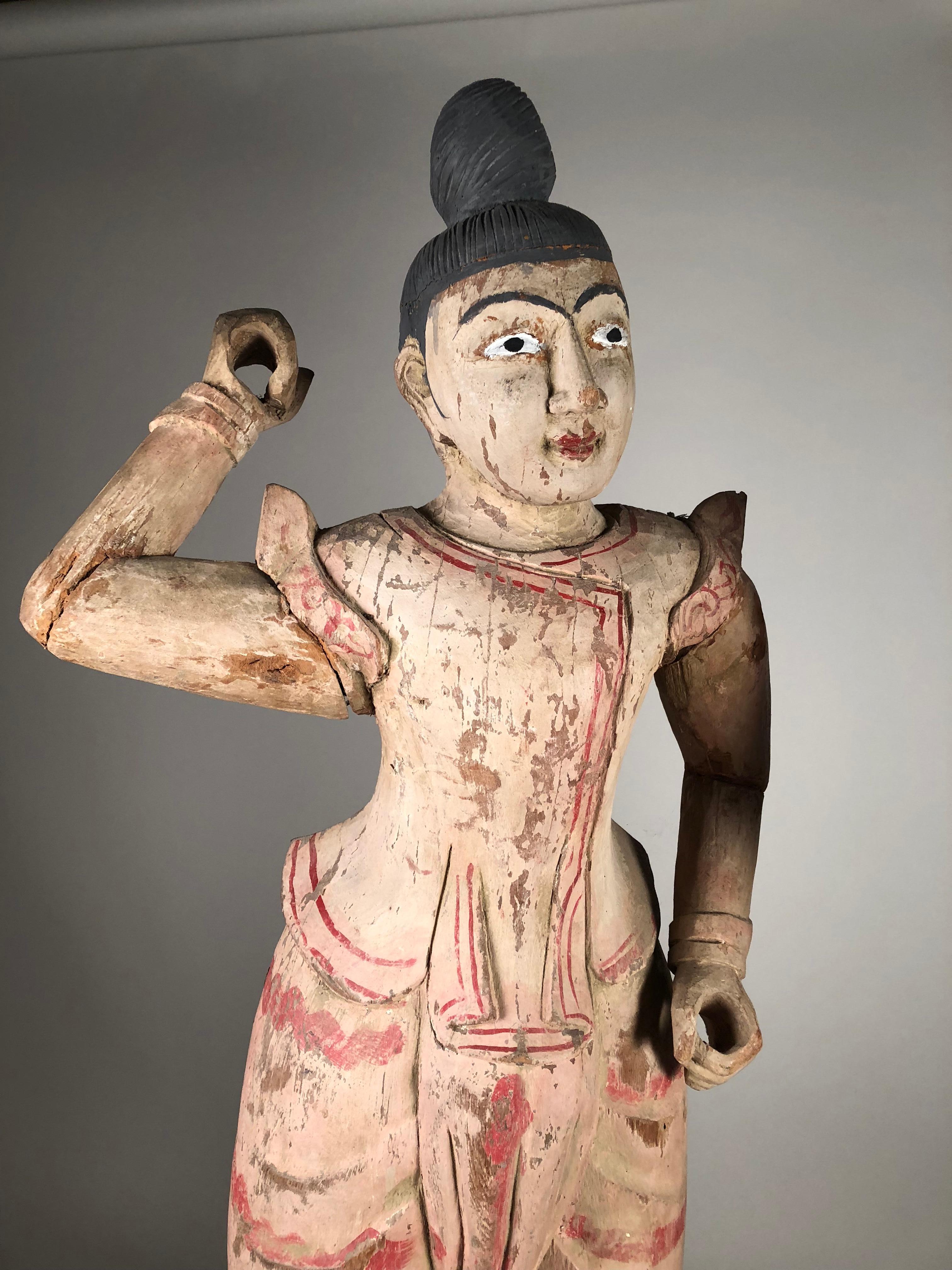 A large pair of male and female Balinese figural statues in carved wood with painted finish representing dancers. Early 20th century.