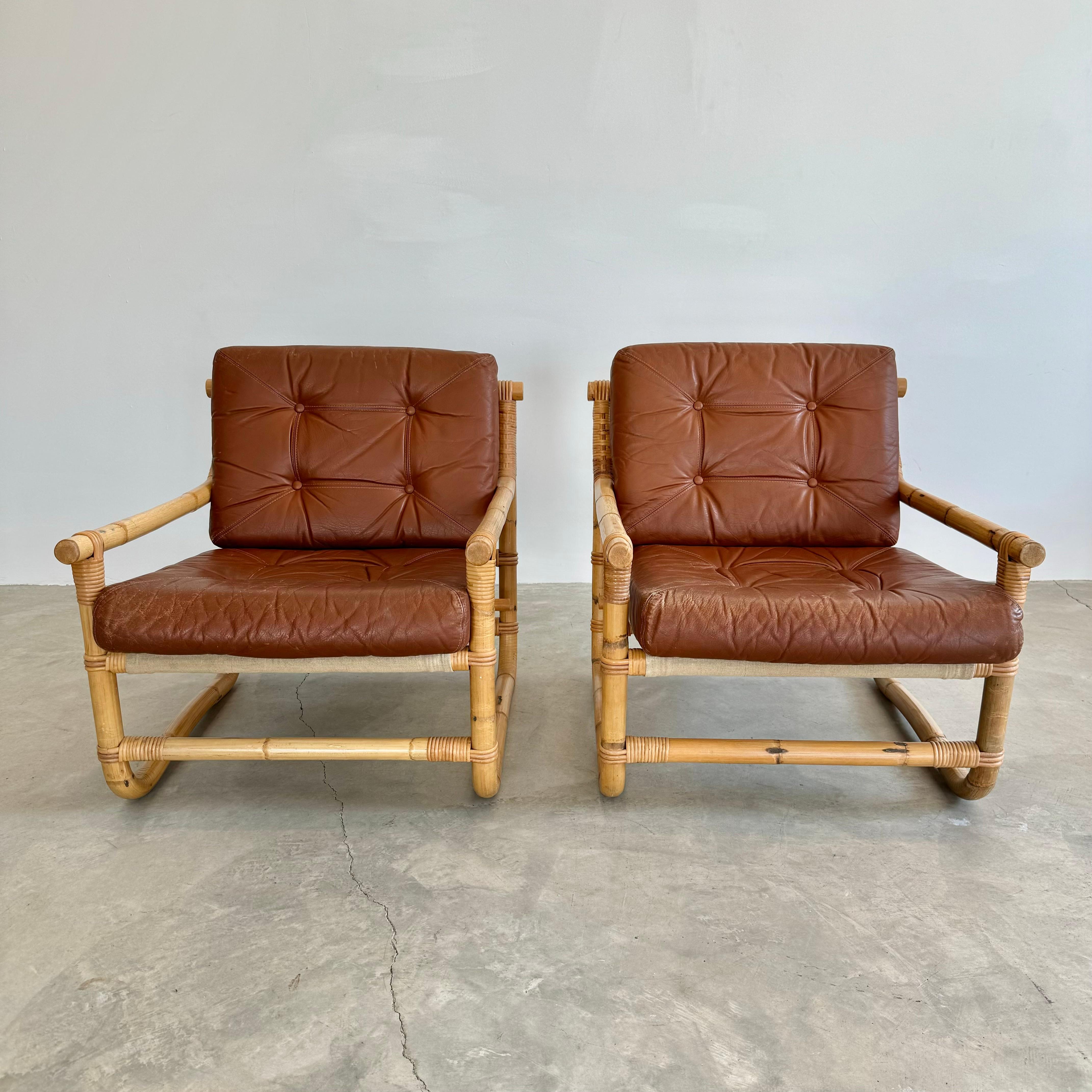 Incroyable paire de chaises danoises en cuir brun et bambou. Très bon état et couleur du cuir avec une légère patine. L'armature est constituée d'épaisses tiges de bambou courbées, reliées entre elles par de solides bandes de rotin tressé. Des