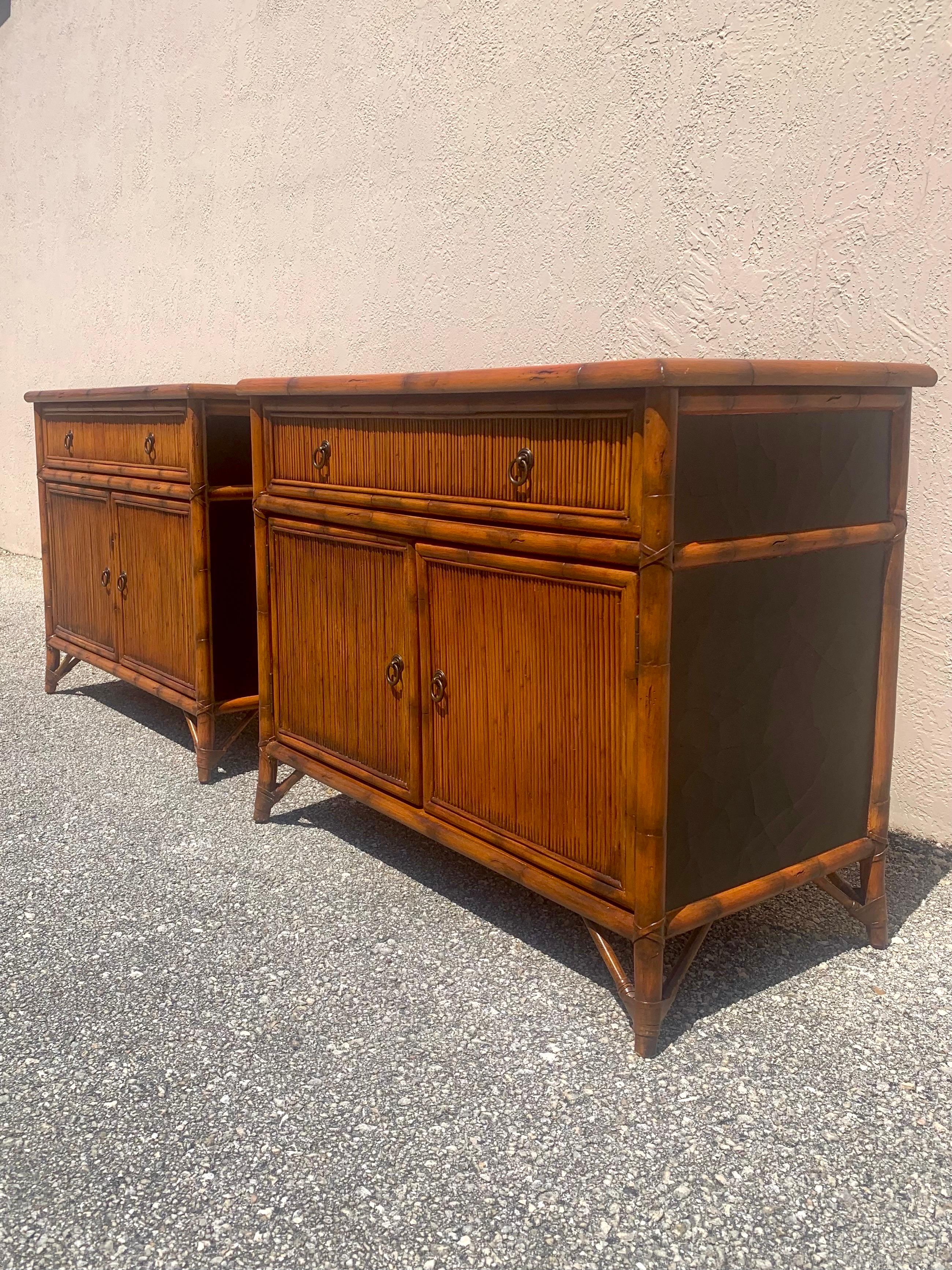 A beautiful pair of Regency style Bachelor chests or Nightstands. 

Made by Baker Furniture. 

Made with a bamboo frame, pencil Reed fronts and a faux crackle leather top. 

Finished to mimic burnt bamboo found throughout different British