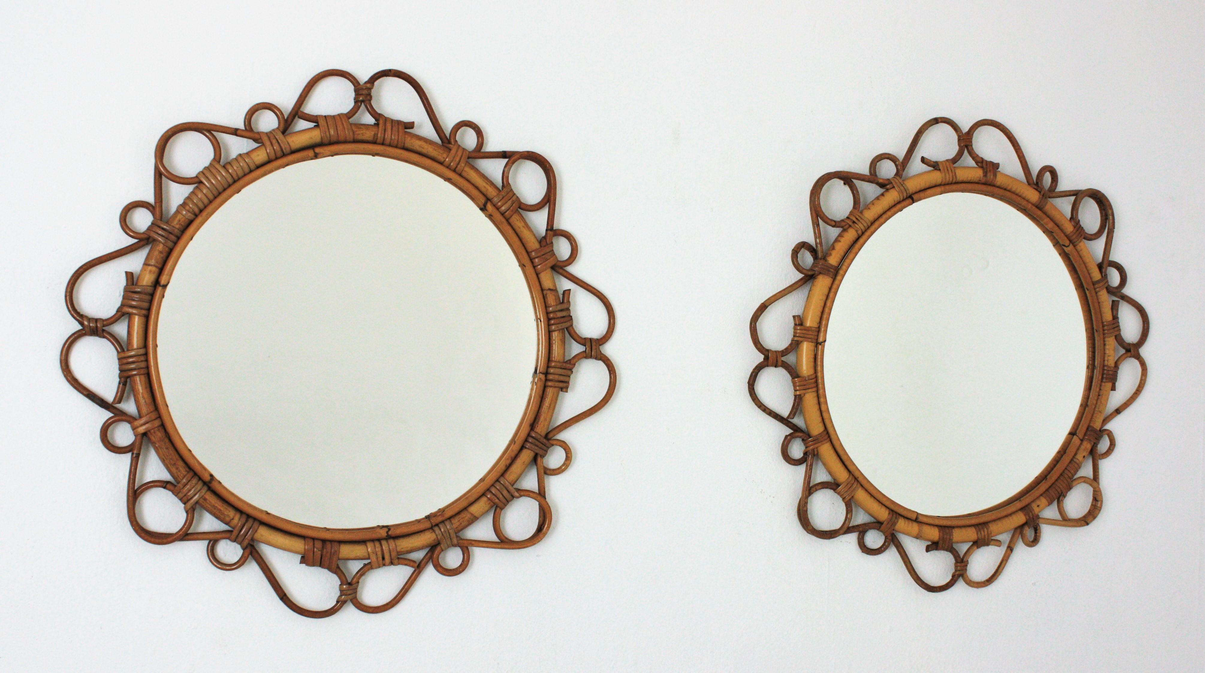 A pair of eye-catching handcrafted bamboo and rattan mirrors with scroll detailings surrounding the frame, Spain, 1960s. 
These Mediterranean wall mirrors feature a circular bamboo frame surrounded by rattan scroll and circle decorations.
They