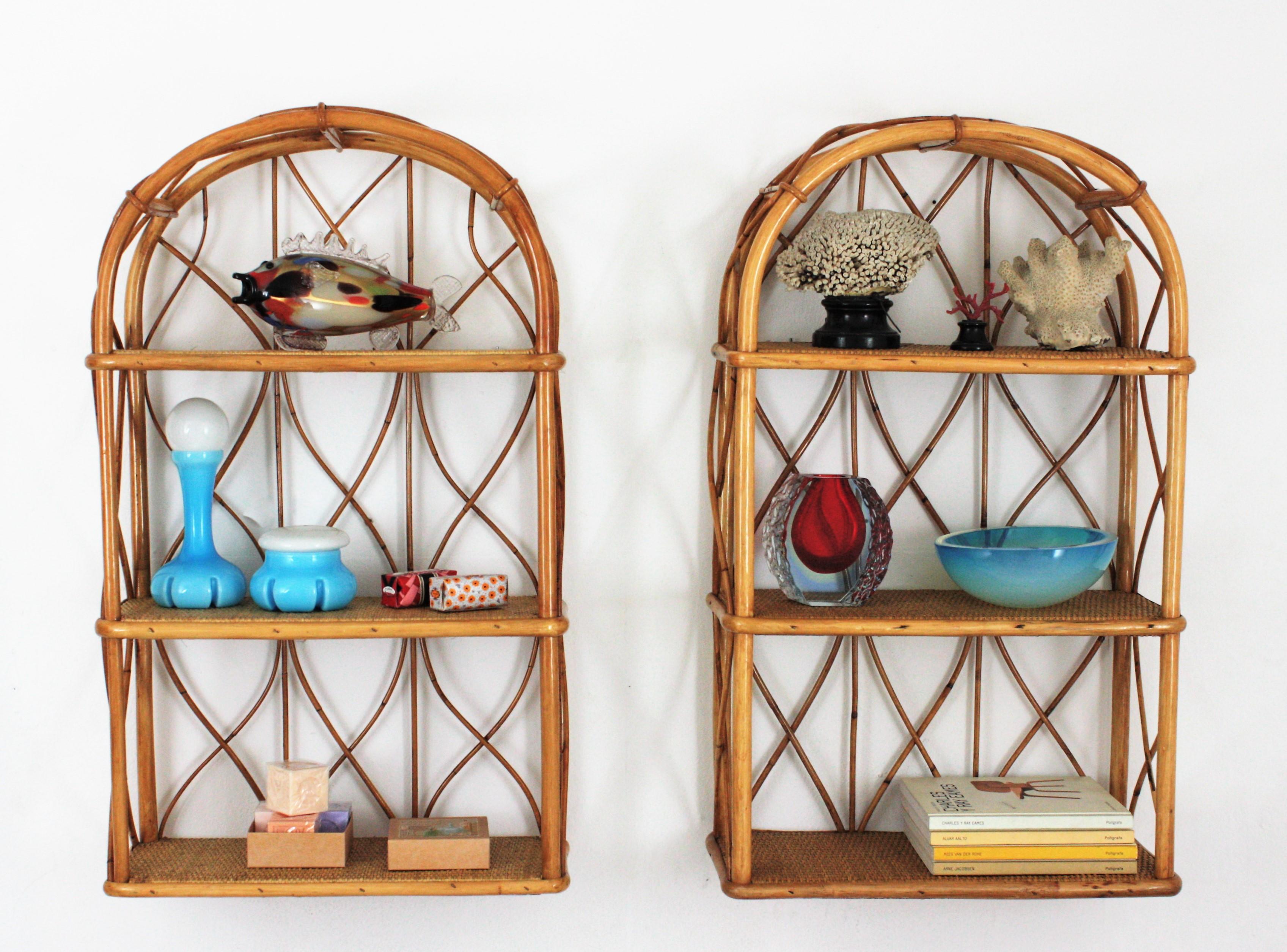 Eye-catching pair of wall hanging shelves or stands in bamboo and rattan, Spain, 1960s.
Each one of these étagères have 3 shelves covered with rattan wire. The structures are made in bamboo with rattan decorative accents at both sides and at the