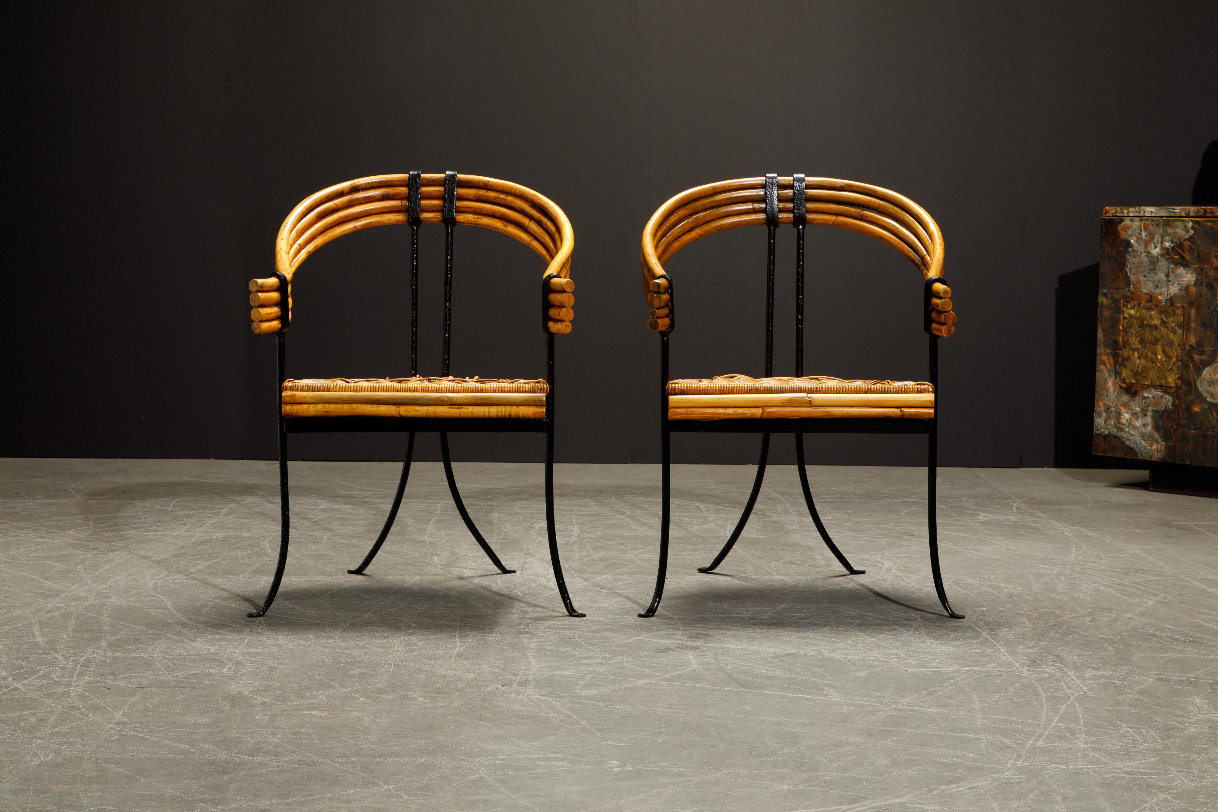 This incredible pair of French Modernist armchairs feature black wrought iron frames with rattan seats and curved bamboo seat backs. The horseshoe shaped bamboo backs provide ample style and character, with the flared black wrought iron legs - these