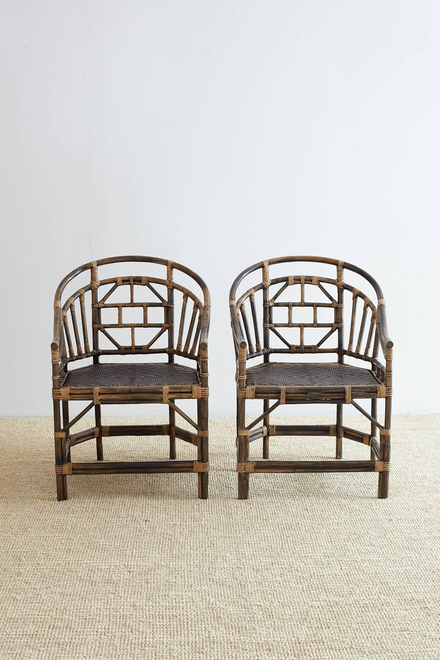 Fabulous pair of Brighton Pavilion style barrel back chairs constructed from bamboo and rattan. Graceful curved arms in a horseshoe shape supported by an open fretwork design in a Chinese Chippendale style. The woven seat is supported by six legs