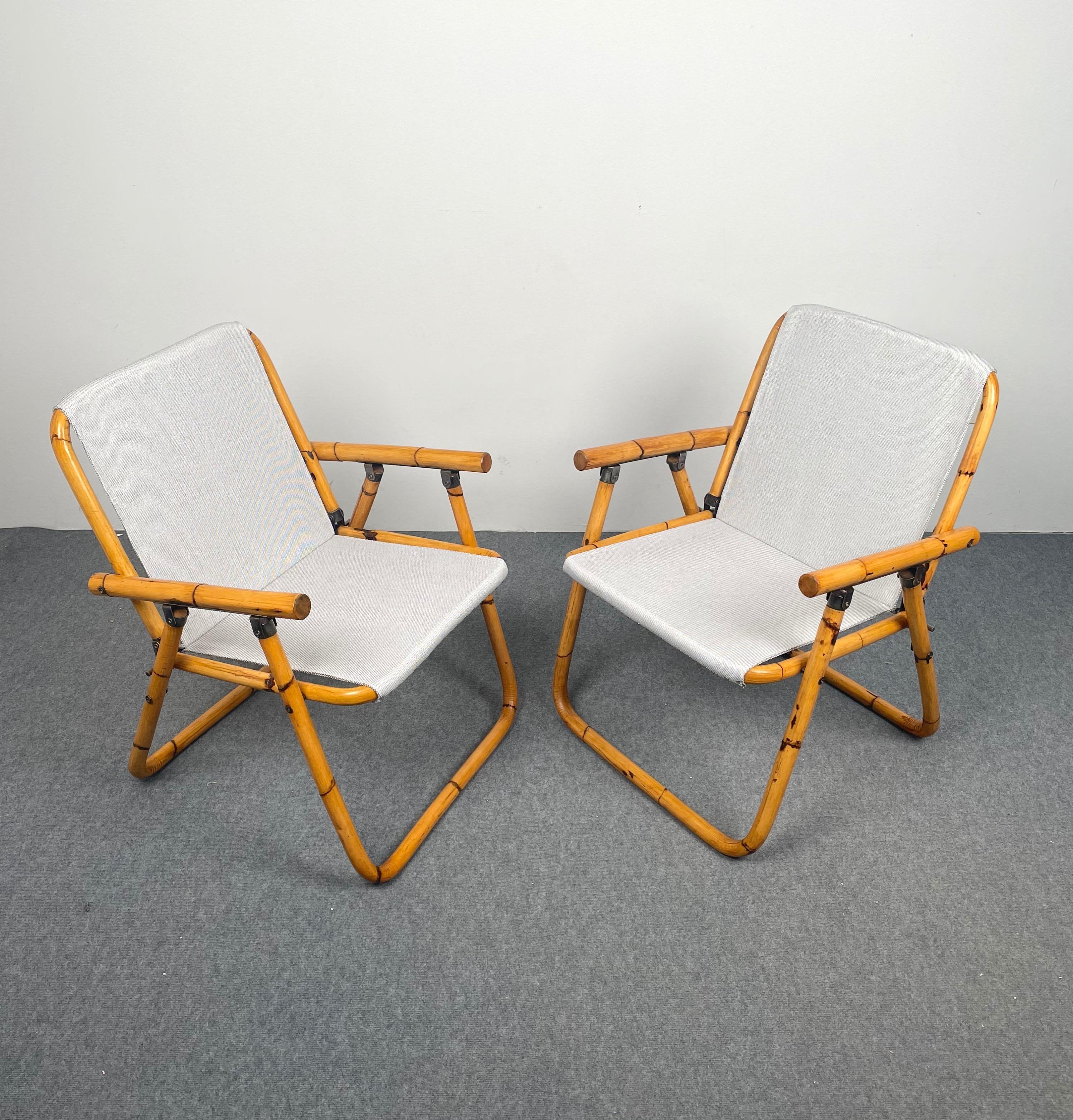 Pair of folding chairs in bamboo and fabric made in Italy in the 1960s. 
The chairs have been restored: the fabric is new and the bamboo has been polished.
