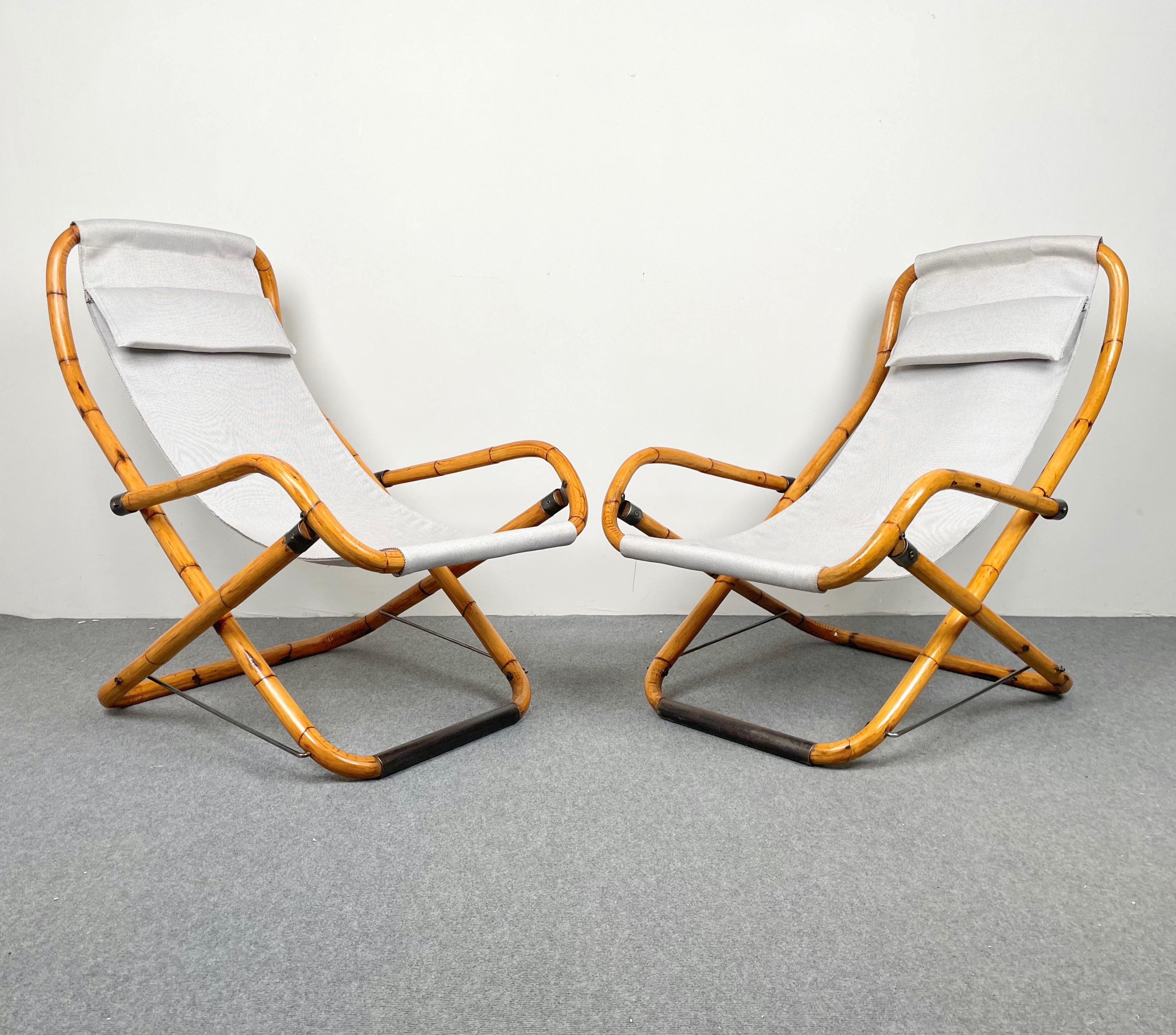 Paire de chaises longues pliantes en bambou et tissu fabriquées en Italie dans les années 1960. 
Les chaises ont été restaurées : le tissu est neuf et le bambou a été poli.