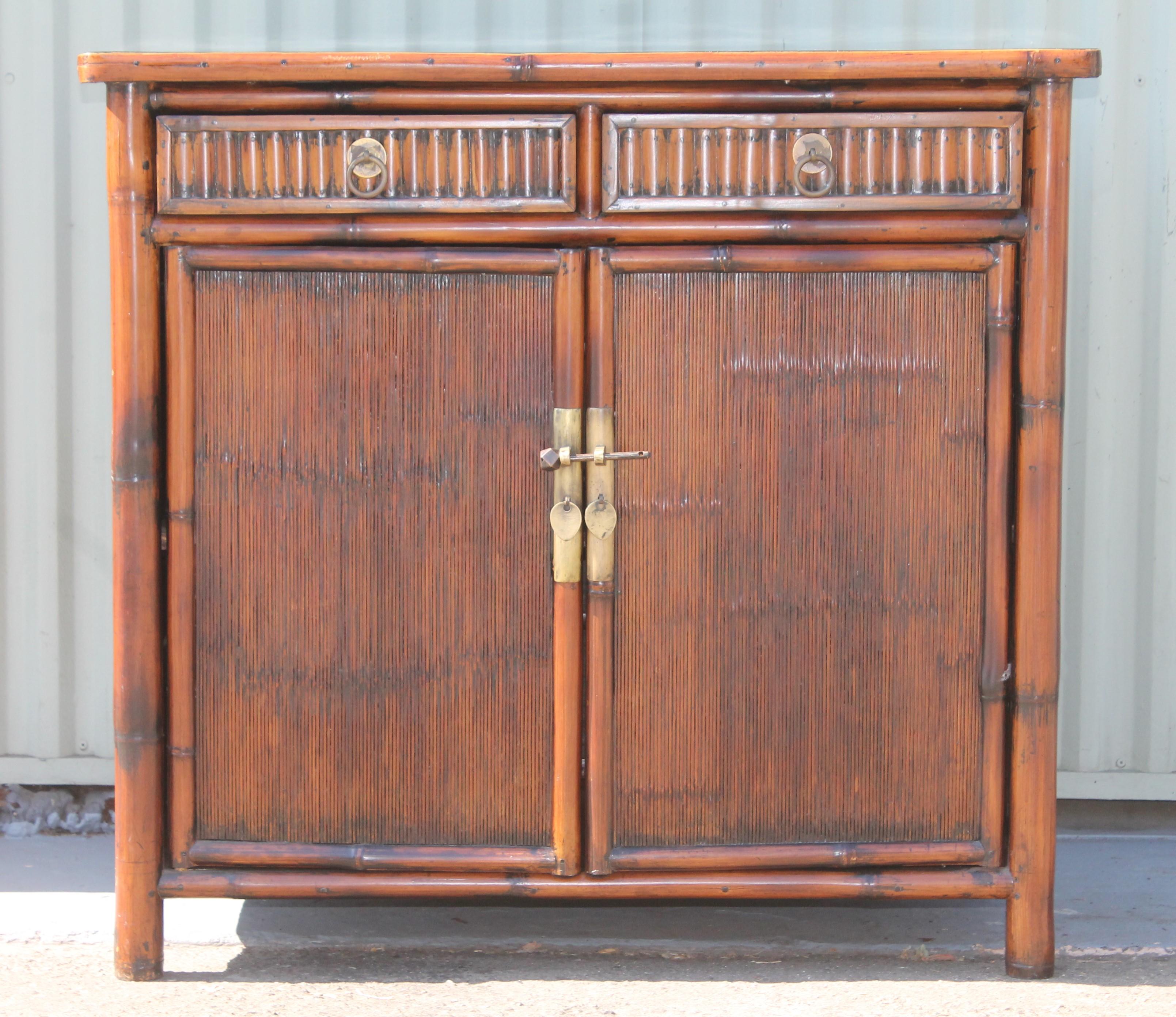 Fantastic 20th century Chinese bamboo bedside cabinets / great end tables as well. The condition is very good with black enameled tops of cabinets. The condition is very good with all original brass hardware.