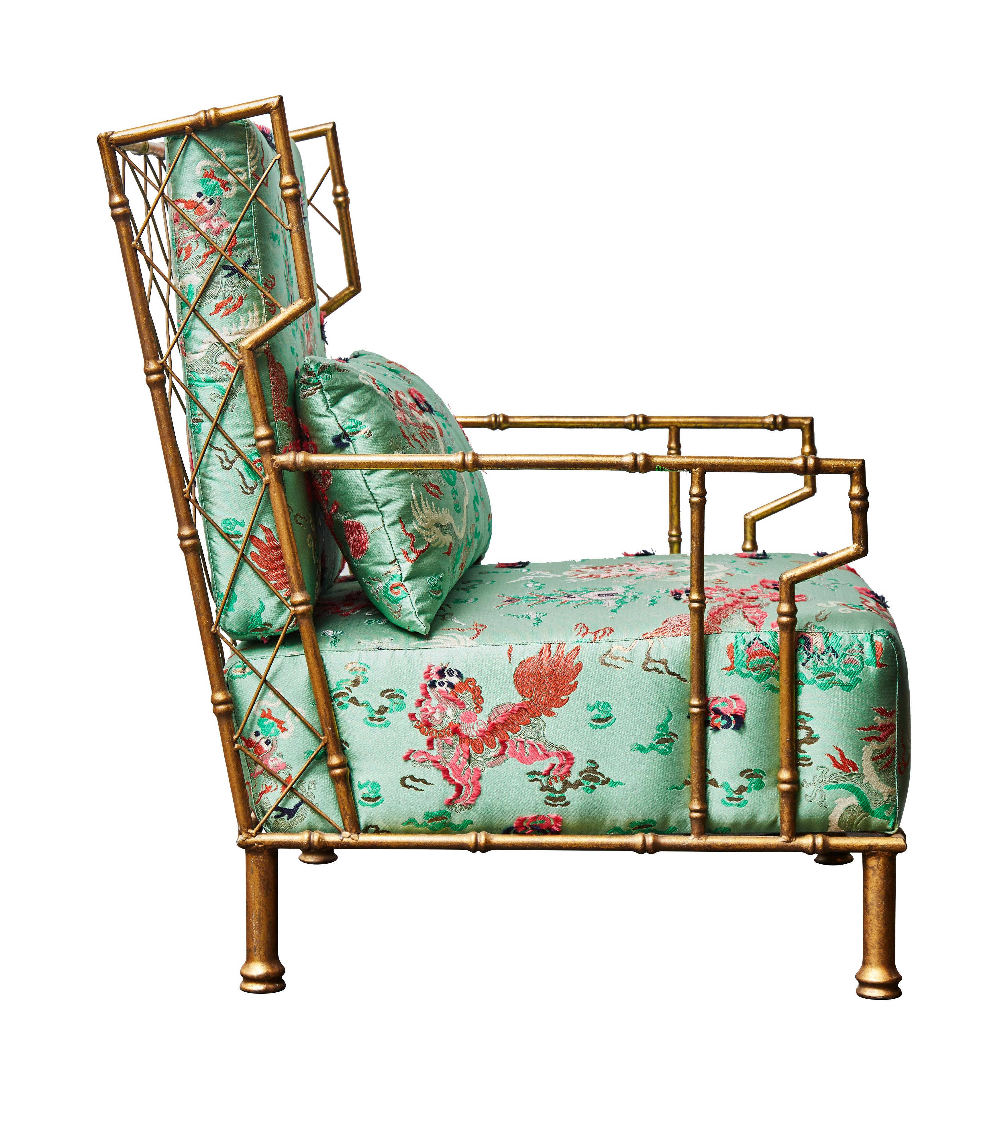 This pair of armchairs is in gilded metal shaped as bamboos. All three cushions - seat, back plus one - are upholstered in a chinoiserie Dedar fabric.