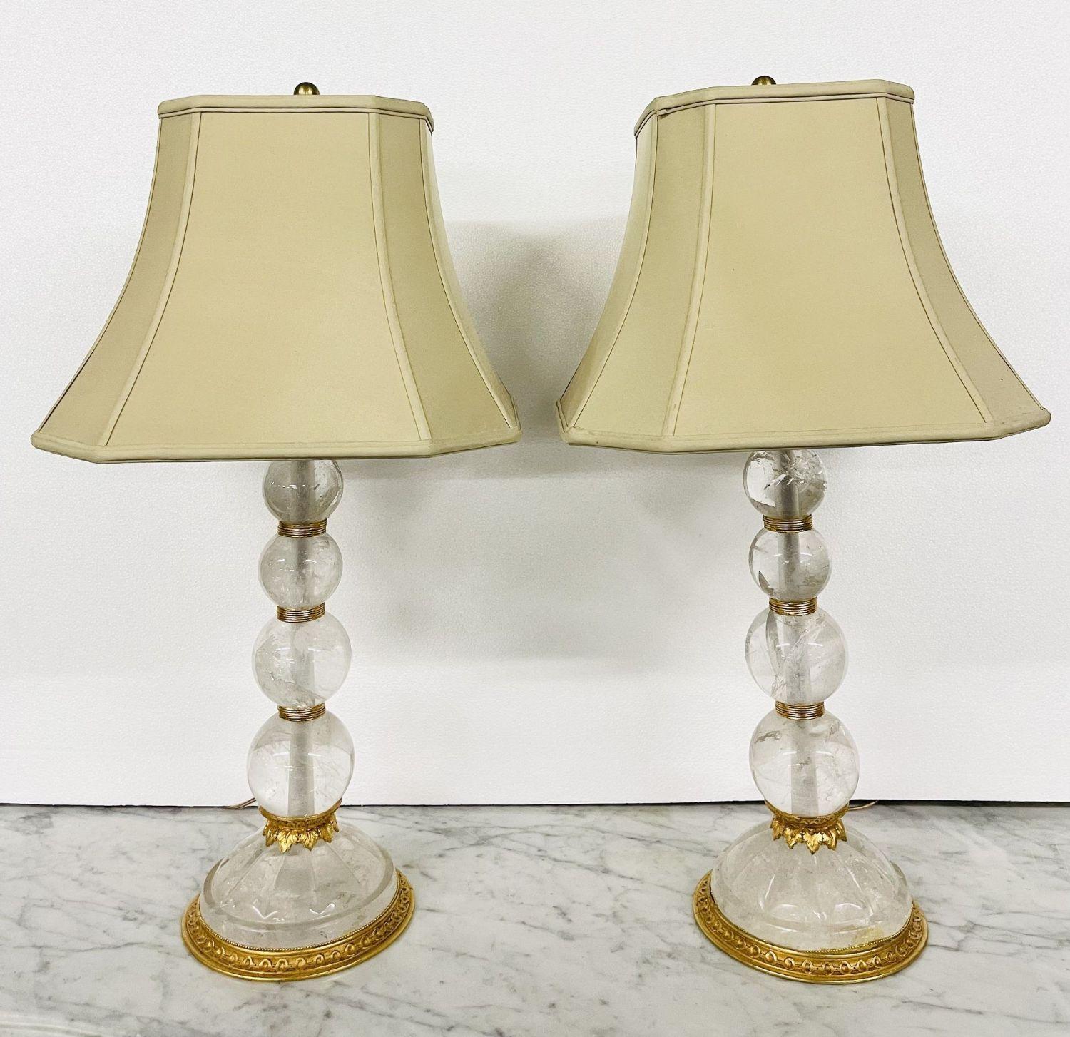 A pair of Baques Rock crystal table lamps having four circular spheres on a Rock Crystal base all separated by gilt bronze supports. Fine rock crystal on this suburb pair of French table lamps by this highly sought after designer. These are not