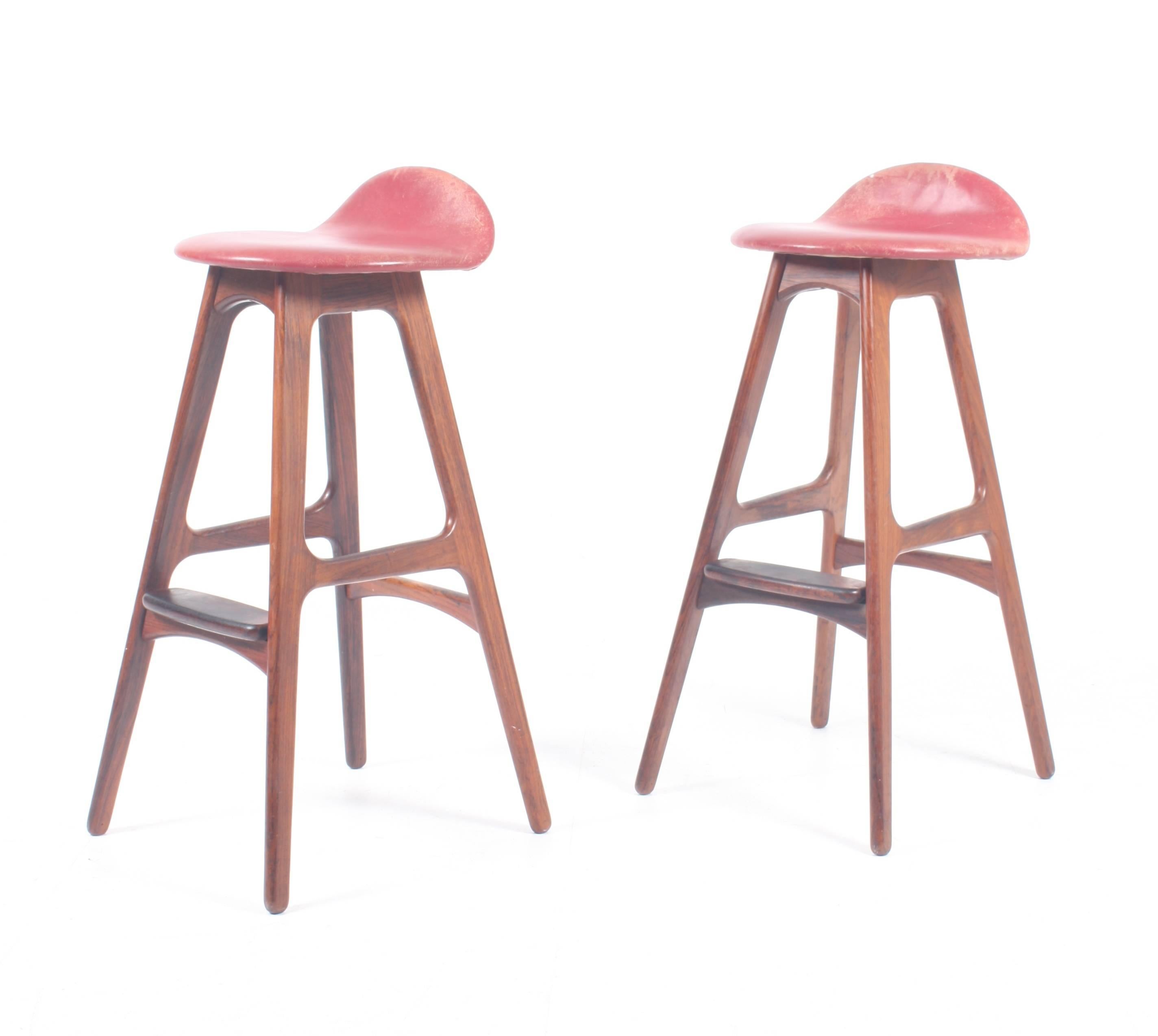 Pair of great looking bar stools in solid rosewood with a nicely shaped seat in red patinated leather. Designed by Erik Buch for Odense Møbelsnedkeri in 1965. Made in Denmark.