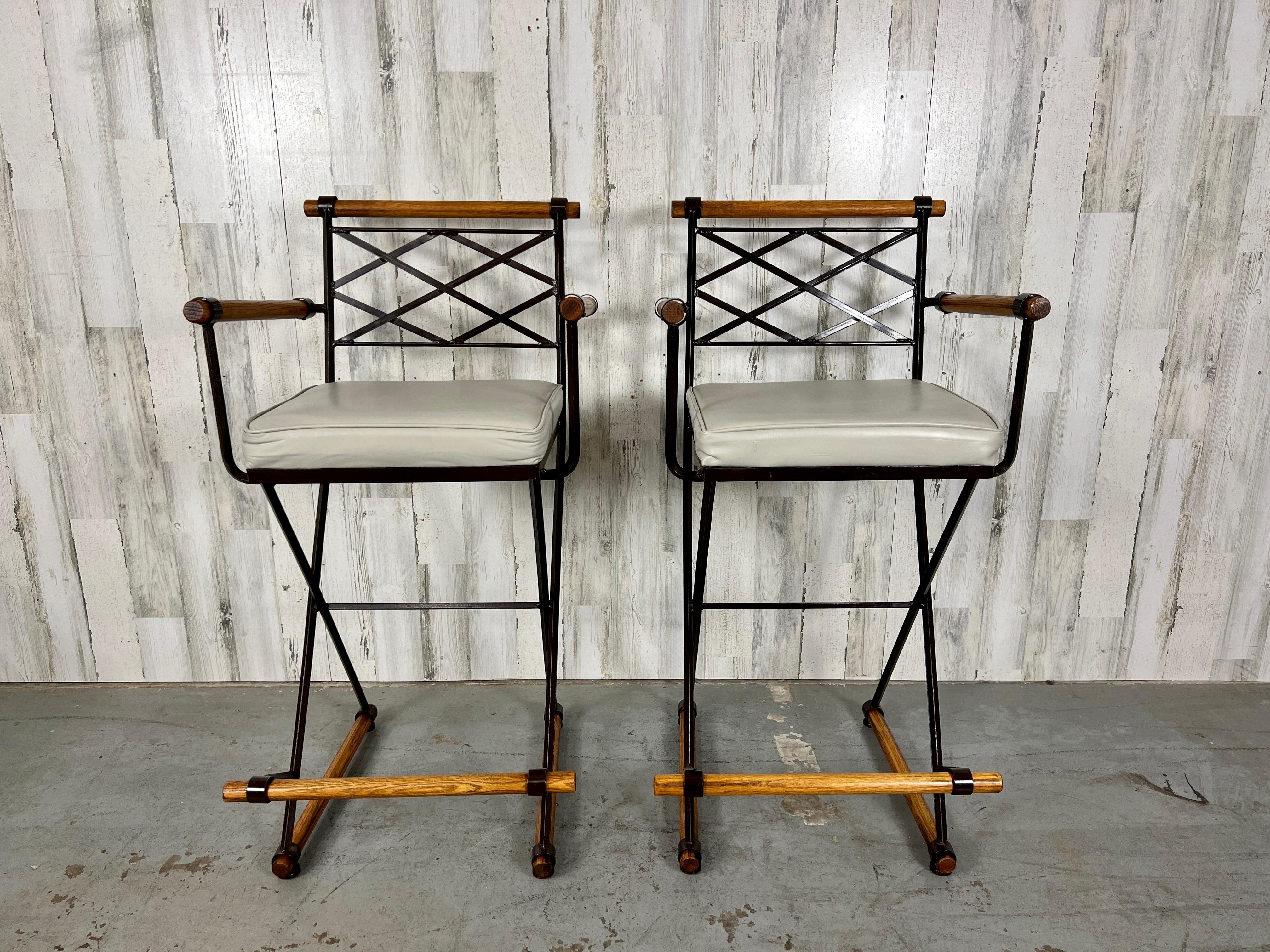 A duo of bar stools from Inca Products, USA, dating back to the 1960s and inspired by the design aesthetics of Cleo Baldon. These stools showcase a wrought iron framework in chocolate brown powder-coat with intricately designed lattice backrests.
