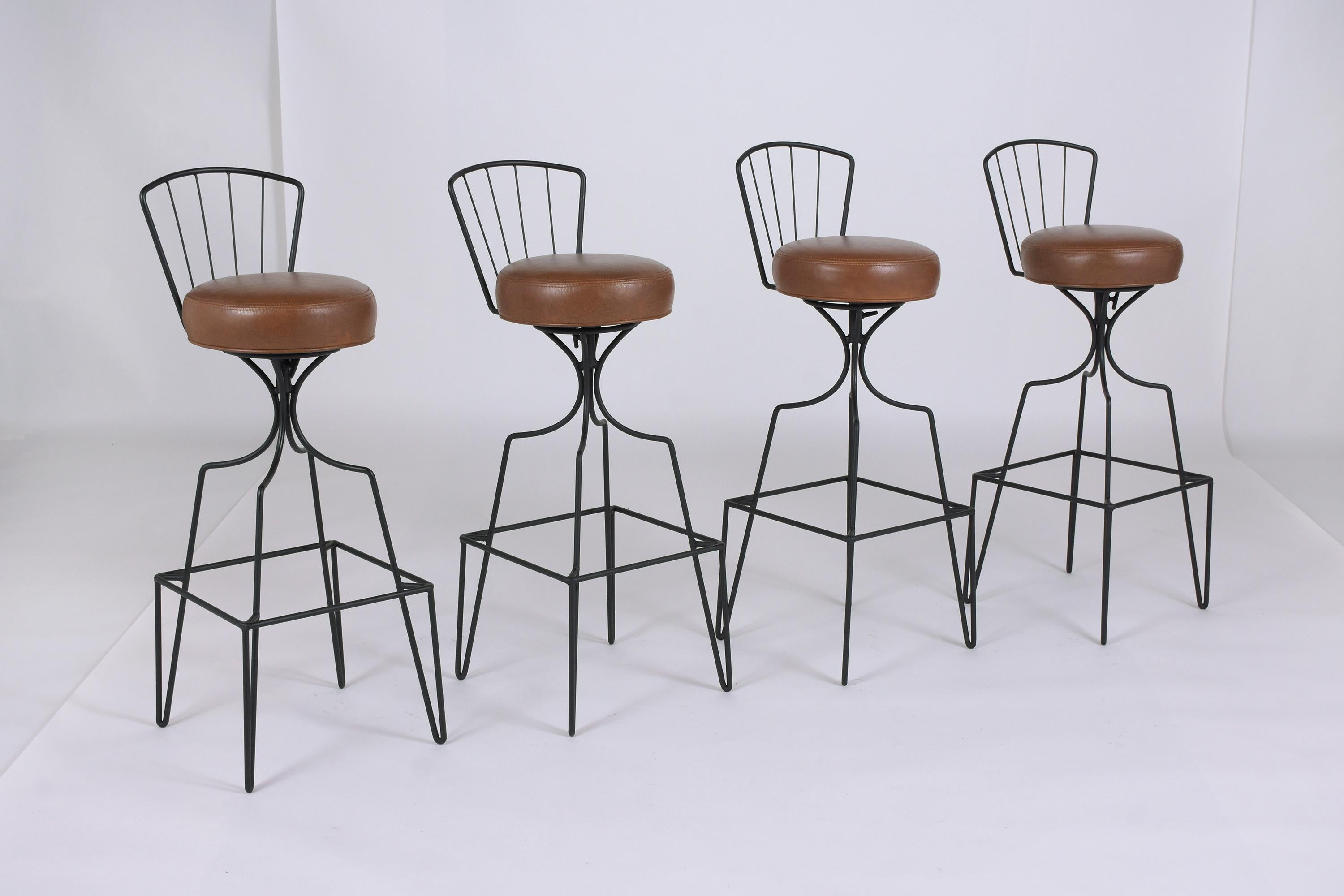 This vintage set of four bar stools is in great condition and has been newly restored by our team of in-house craftsmen. The stools have round seat cushions newly upholstered in brown leather with topstitch & single piping details, the seats rest on