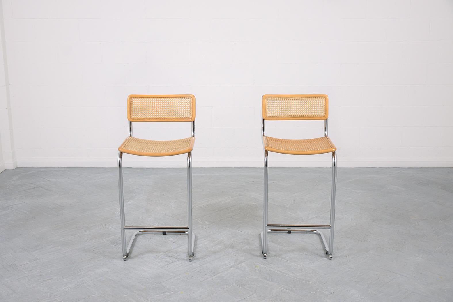 These extraordinary pair of mid-century barstools from Marcel Breuer are in great condition and have been newly restored by our team of expert craftsmen. The frames are beautifully hand-crafted out of steel, this pair is eye-catching and features a