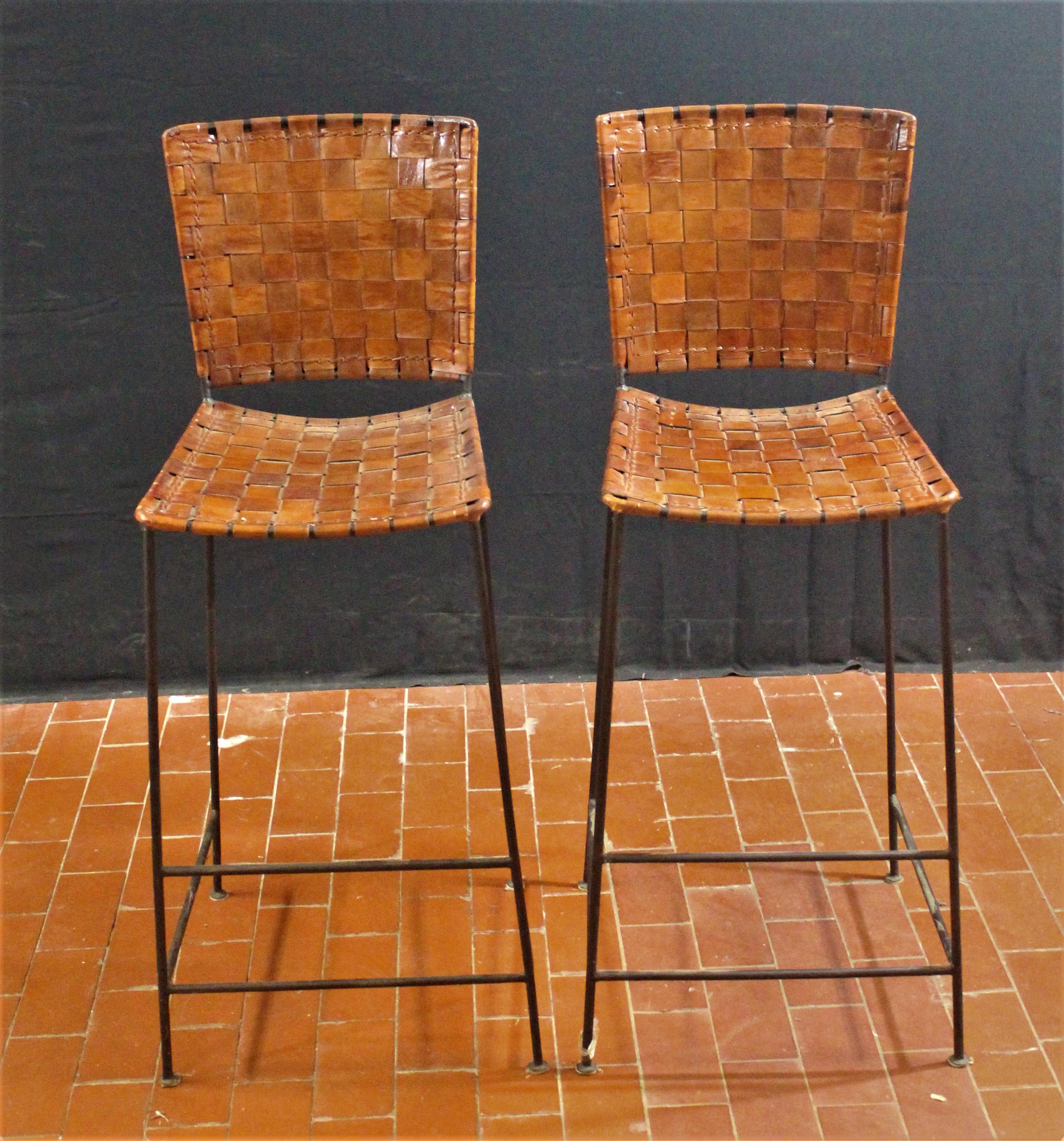 Pair of bar stools in woven saddle brown leather.