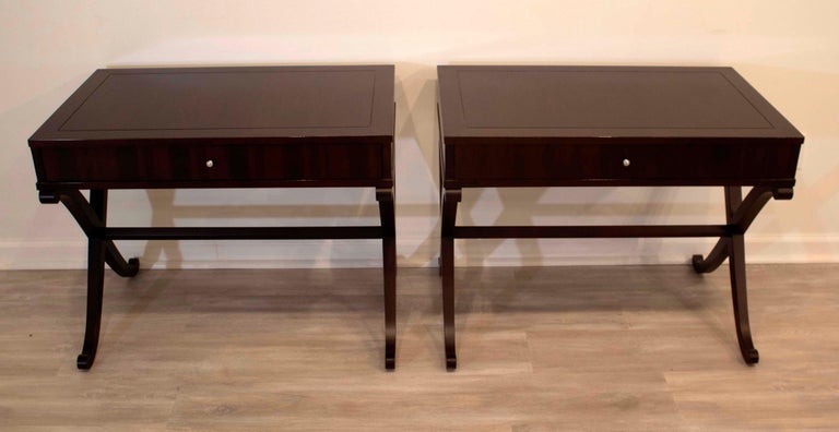 This fantastic matching pair of Barbara Barry for Baker side or end tables each have a single drawer detailed with silver hardware pulls and supported by sophisticated 'X' shaped bases. In very good condition.

Dimensions: 32W x 20D x 25H.