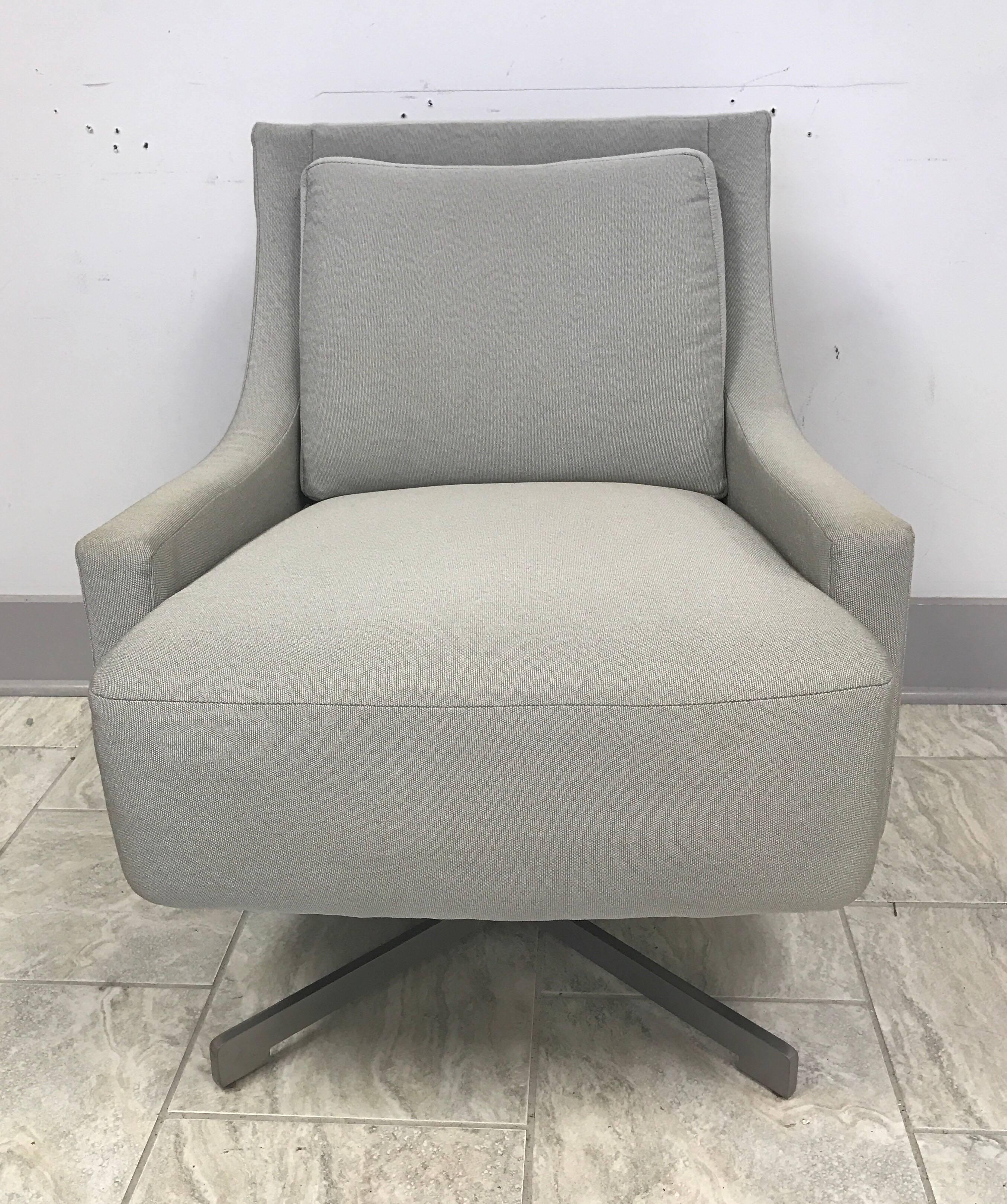 Paire de chaises pivotantes HBF:: conçues par Barbara Barry:: à la fois élégantes et confortables:: reposant sur une base en acier autocentrée à quatre branches et revêtues d'un luxueux tissu gris.