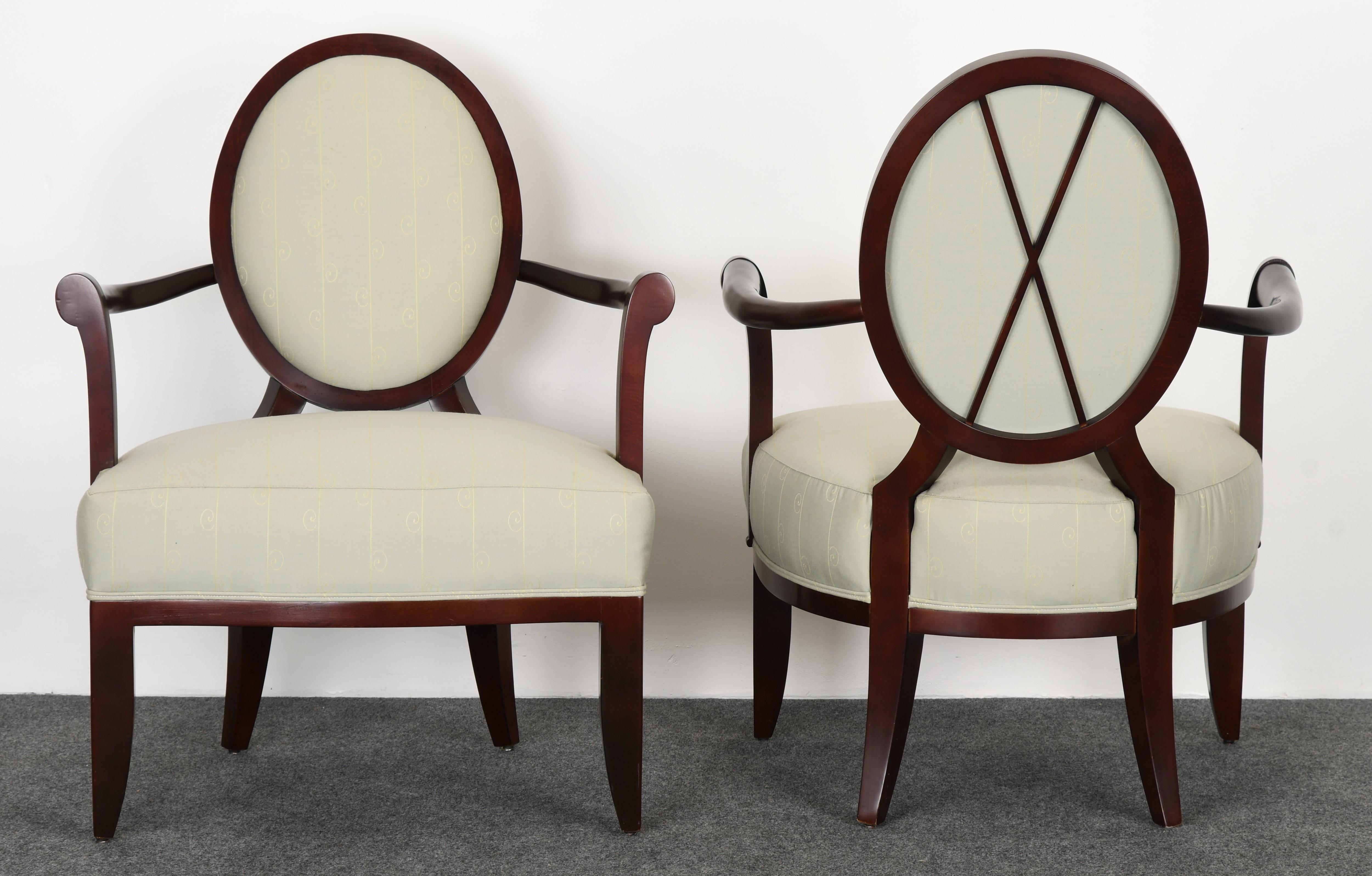 A gorgeous pair of Barbara Barry oval X-back lounge armchairs for Baker Furniture, 1990s. The chairs are made of maple with a mahogany finish upholstered in a light green fabric. The fabric is vintage but is in good condition overall with some minor