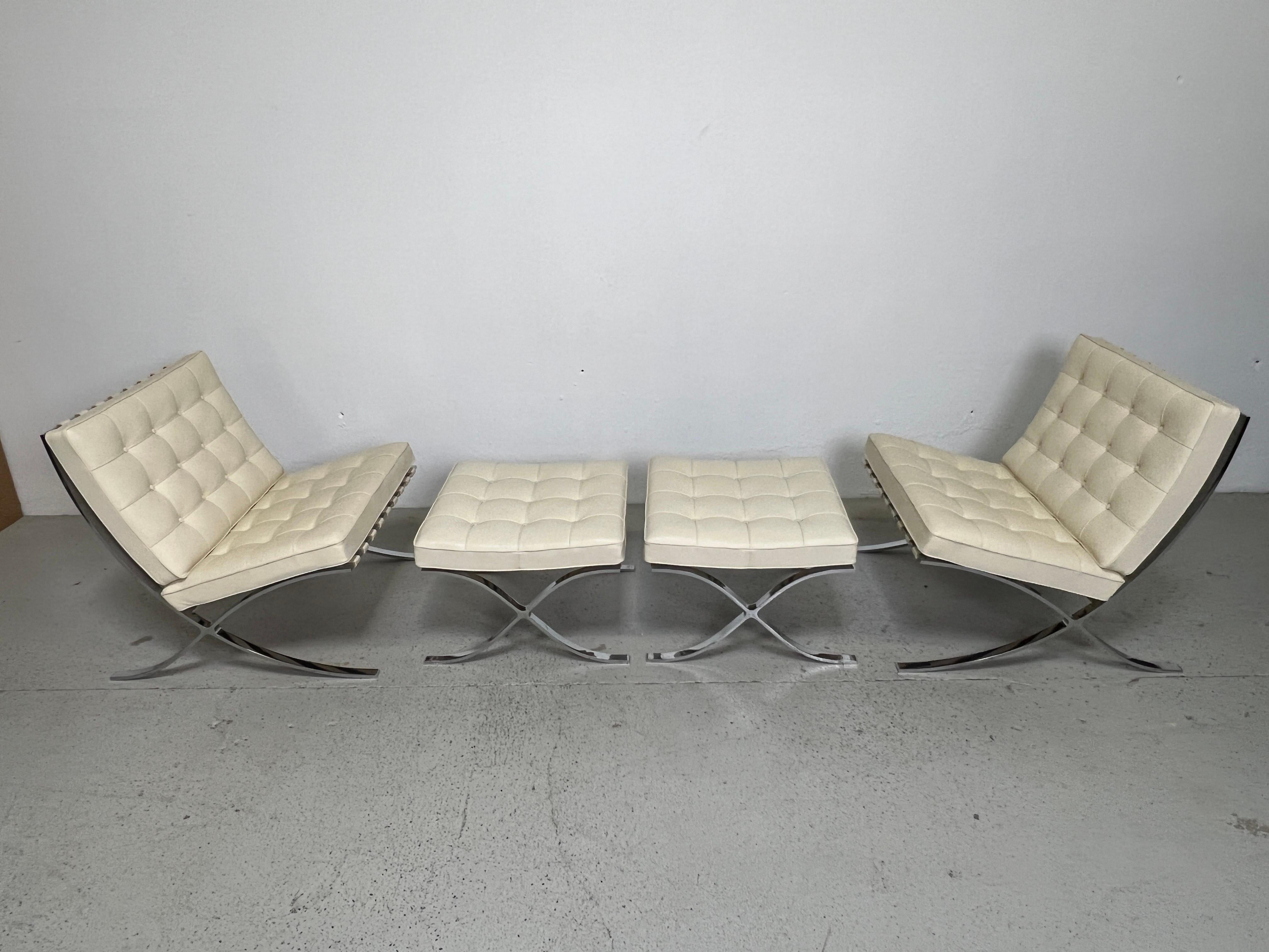 A matching pair of Barcelona chairs and ottomans designed by Mies van der Rohe for Knoll. This set from the 2000s with a buttery soft cream colored leather. 