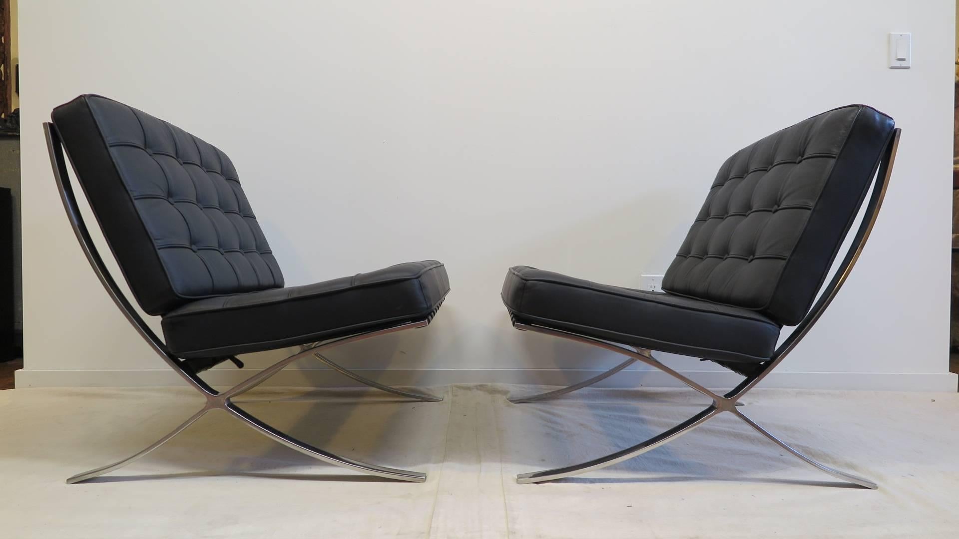 A pair of black leather Barcelona style chairs. Very high quality replica reproductions in excellent condition. 
Order date 2004, from a NYC executive office. A very good buy. Excellent condition.