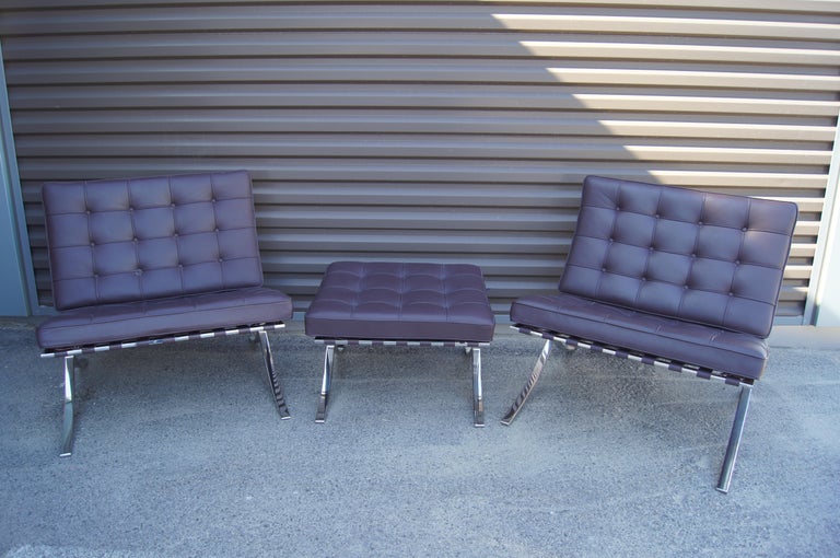 Designed in 1929, Ludwig Mies van der Rohe's Barcelona chair remains an icon of modernist chair design. This pair of chairs and single ottoman, later Knoll productions, feature hand-polished premium-grade stainless-steel frames with hand-tufted