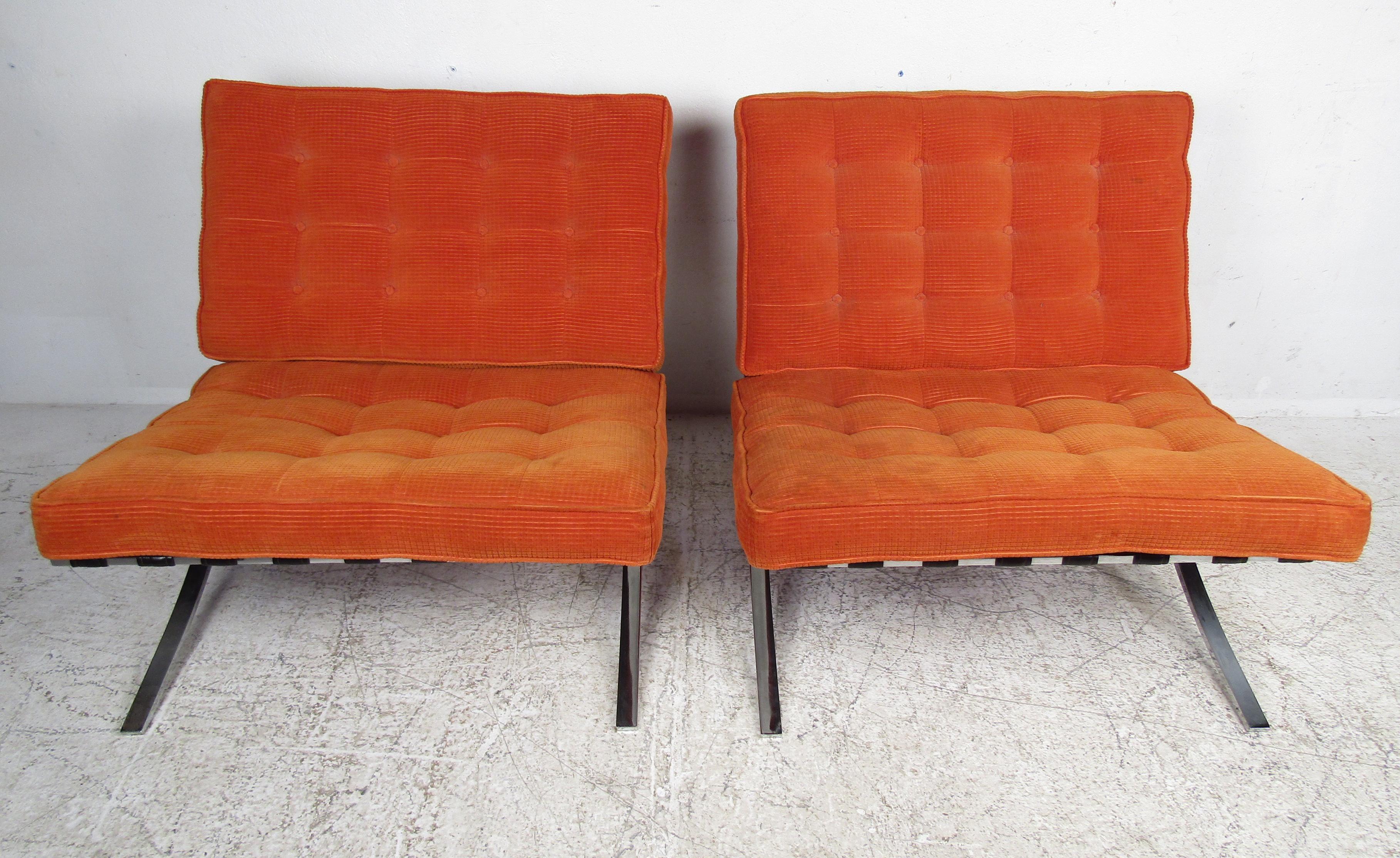 This beautiful pair of contemporary lounge chairs feature a heavy chrome frame with leather straps and thick padded orange cushions. The stylish orange tufted upholstery and 