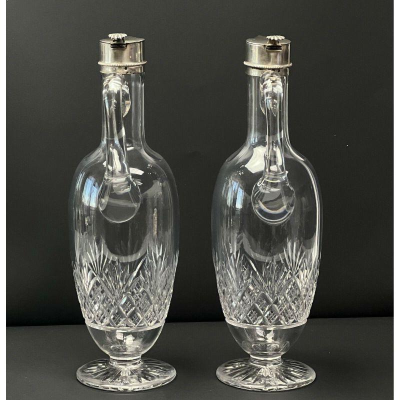 Pair of Barend Enzering Dutch Silver Mounted Cut Glass Pitchers, circa 1825

Glass pitchers with cut fan and diamond pattern to the base, star cut feet. Silver mounted spouts with hinged lids, a shell design to the hinge, beaded pattern around the
