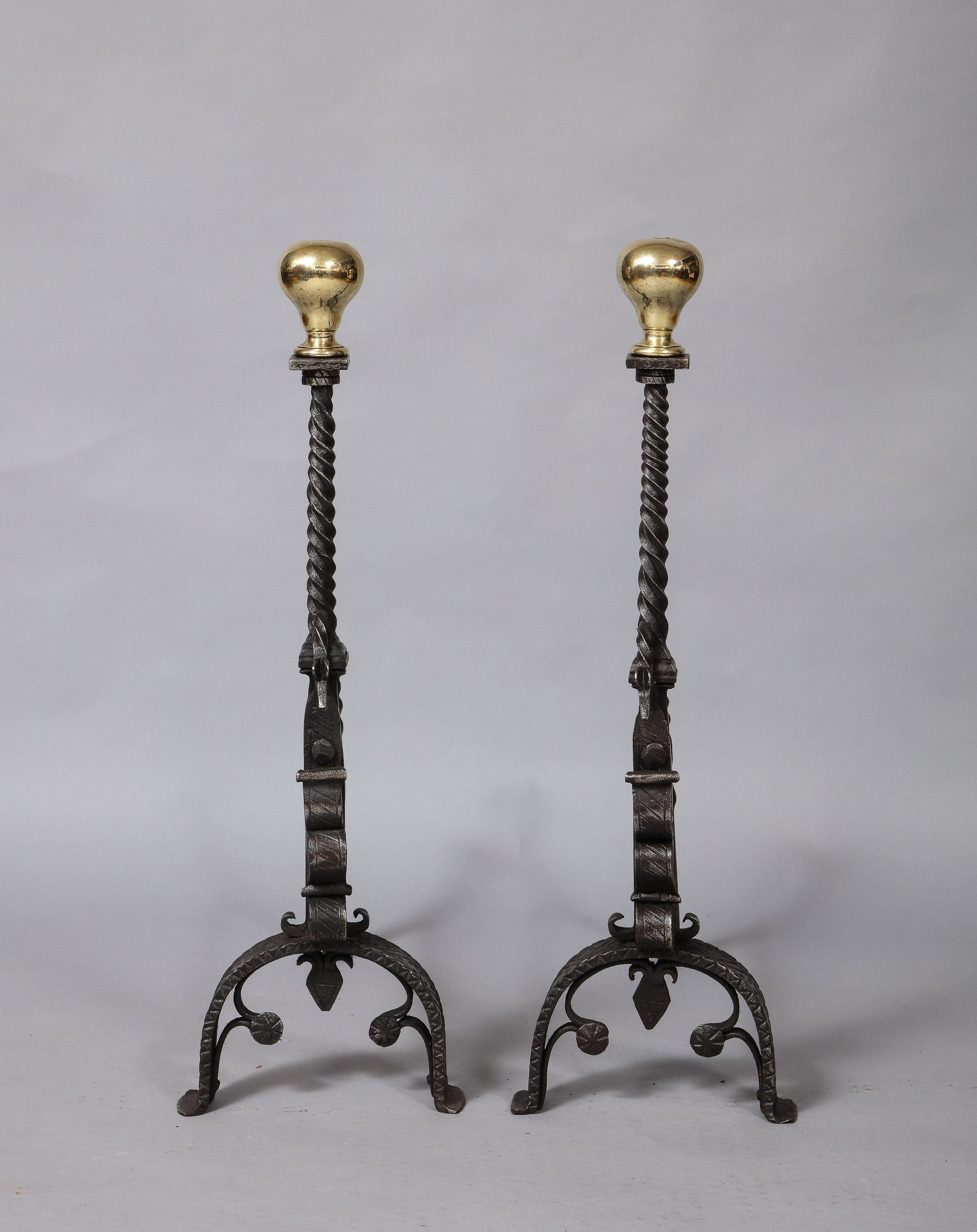 Fine pair of 19th century brass and wrought iron andirons having inverted pair shaped finials over twist turned shafts fronted by serpent heads over scrolled legs with etched decoration having trefoil arches, the backs with twist turned log stops.