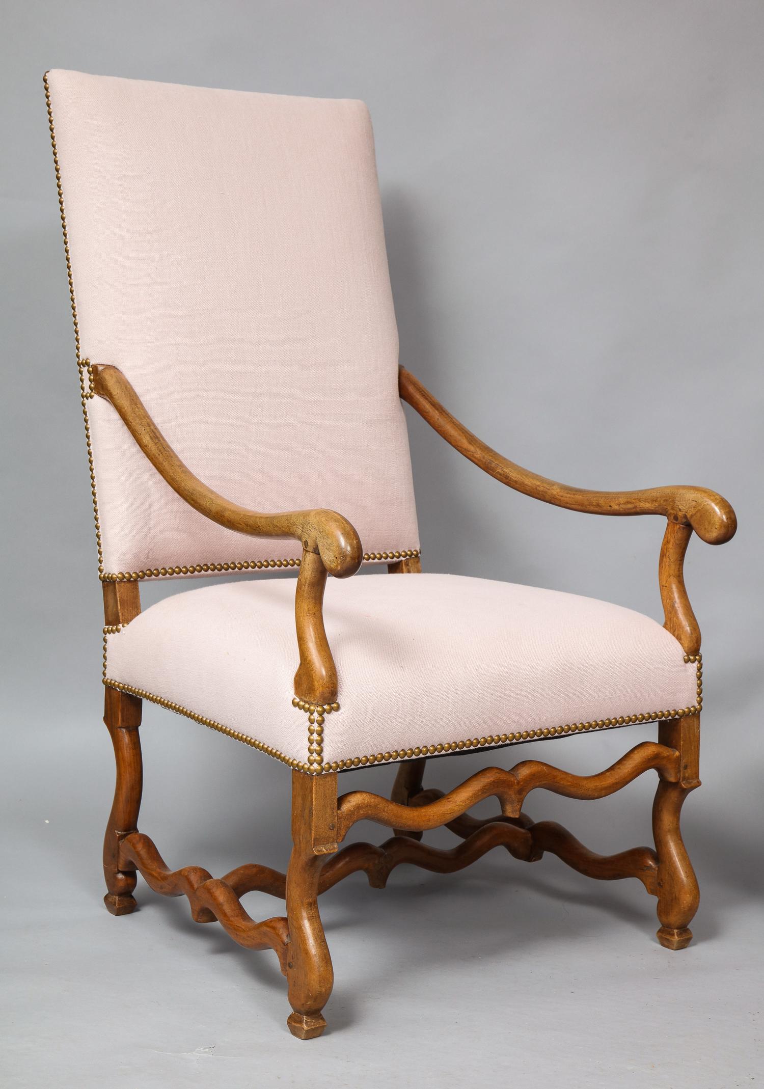 Good pair of French or Flemish walnut Baroque armchairs, having upholstered high squared backs and seats with brass stud detailing now recovered in fresh linen, with downswept arms ending in rolled handles, the legs and stretchers with 