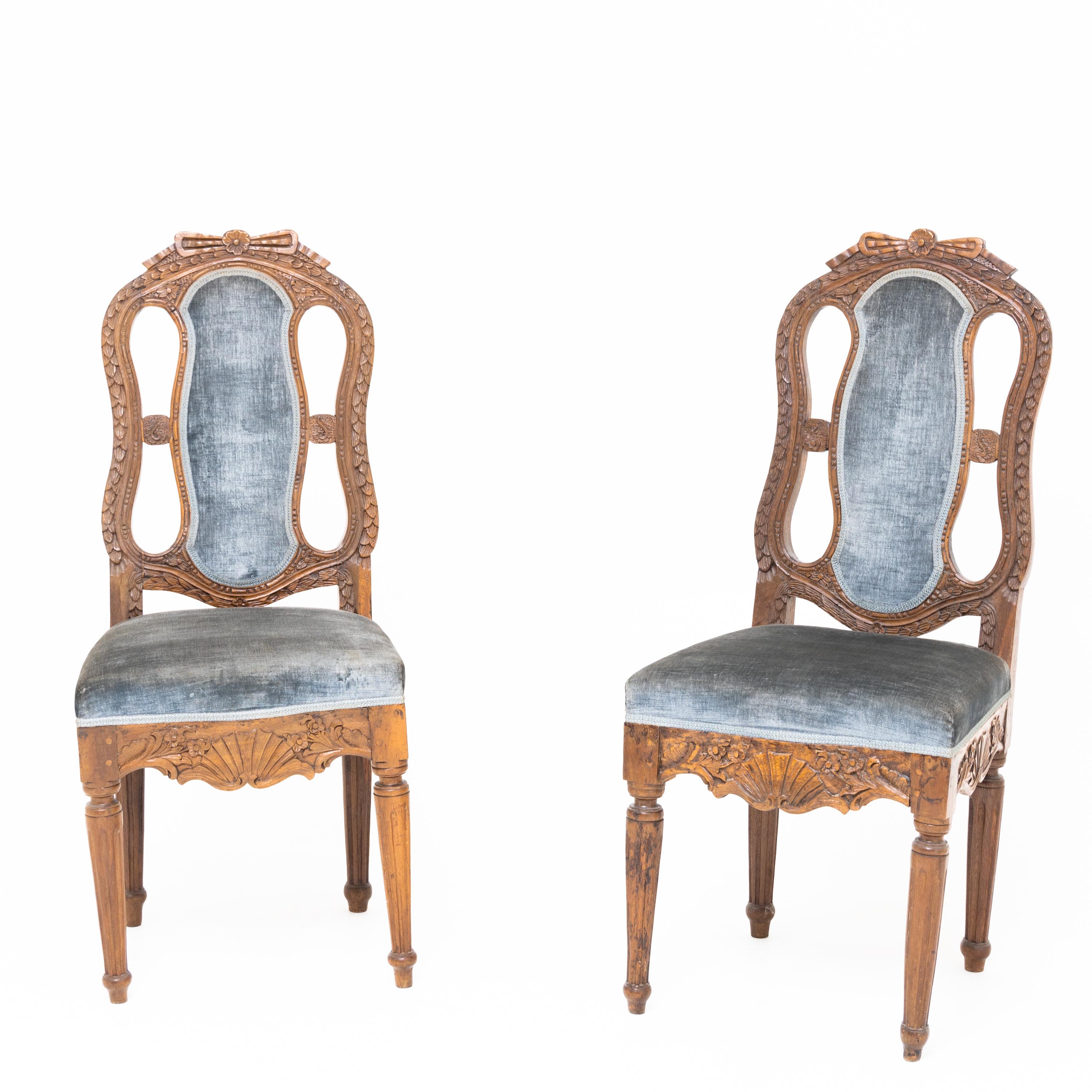 Pair of baroque chairs made of solid oak with openwork backrests with an upholstered centre bar and carved vegetable décor with shell ornament on the curved frame. The chairs are covered with blue velvet. Shown in: Eller, Möbel des Klassizismus,