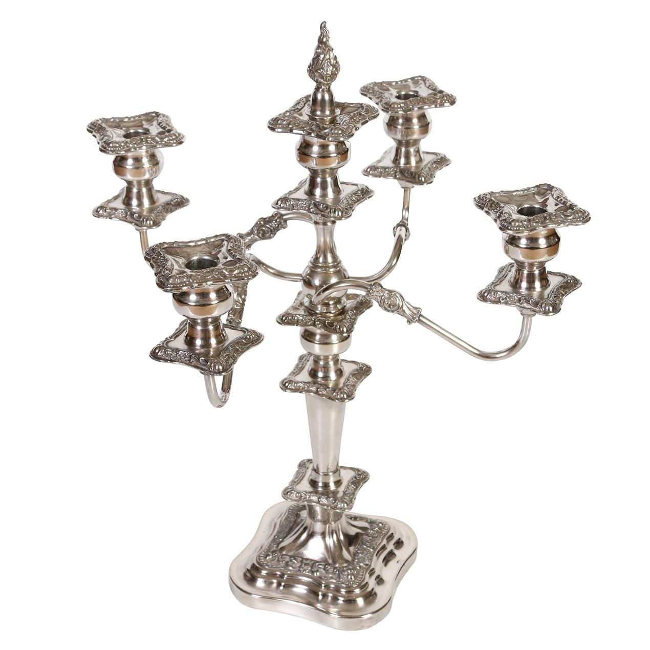 A pair of Baroque five arm silver plate weighted candelabras with detachable arms and candle drip pans and decorated with floral scroll repousse designs. Each arm of the heavy silver candelabra holds a removable drip pan for the candle.  The four