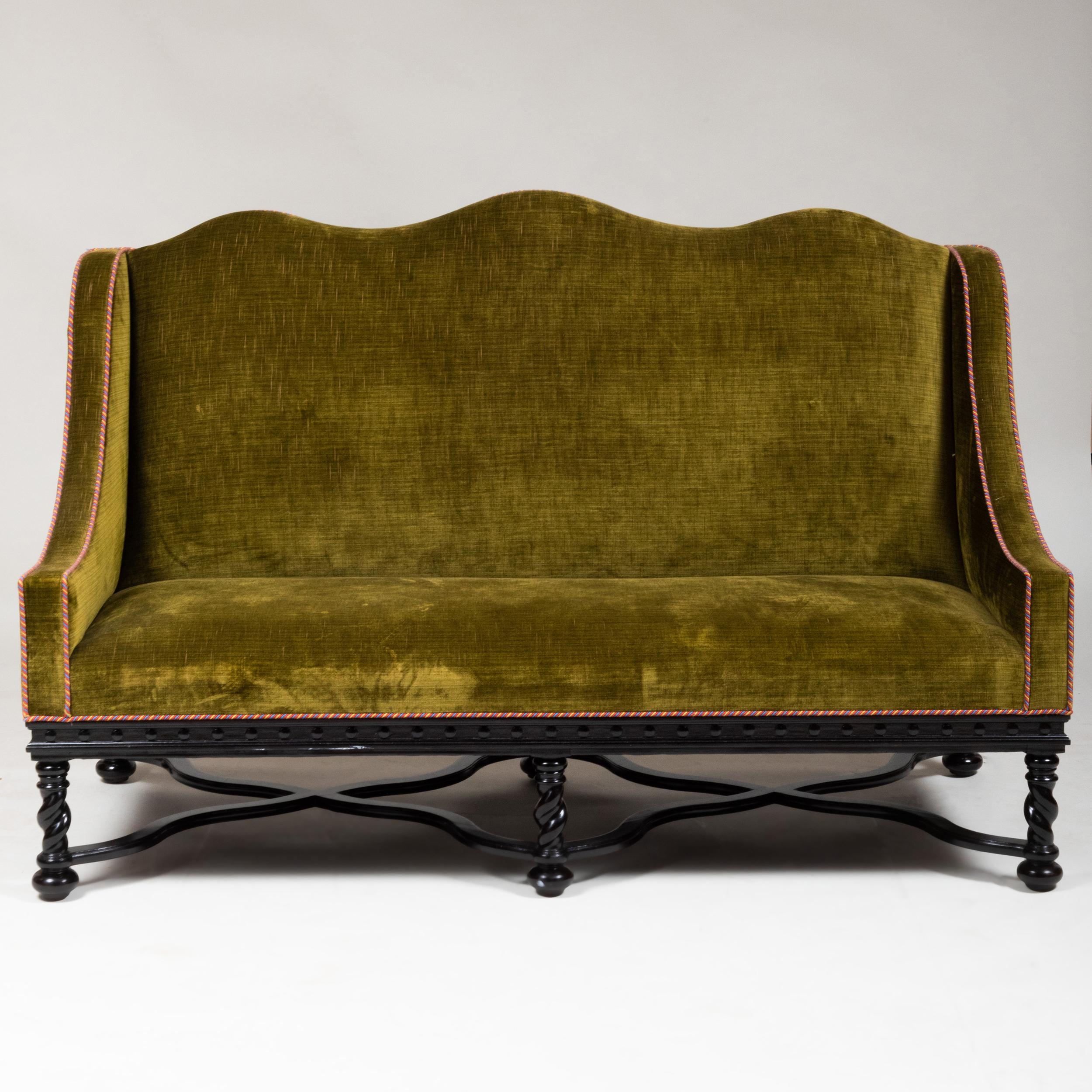 Pair of beautiful Baroque style, camel back sofas, with elegant ebonized frames and turned legs, 
upholstered in an olive green velvet still in good condition.